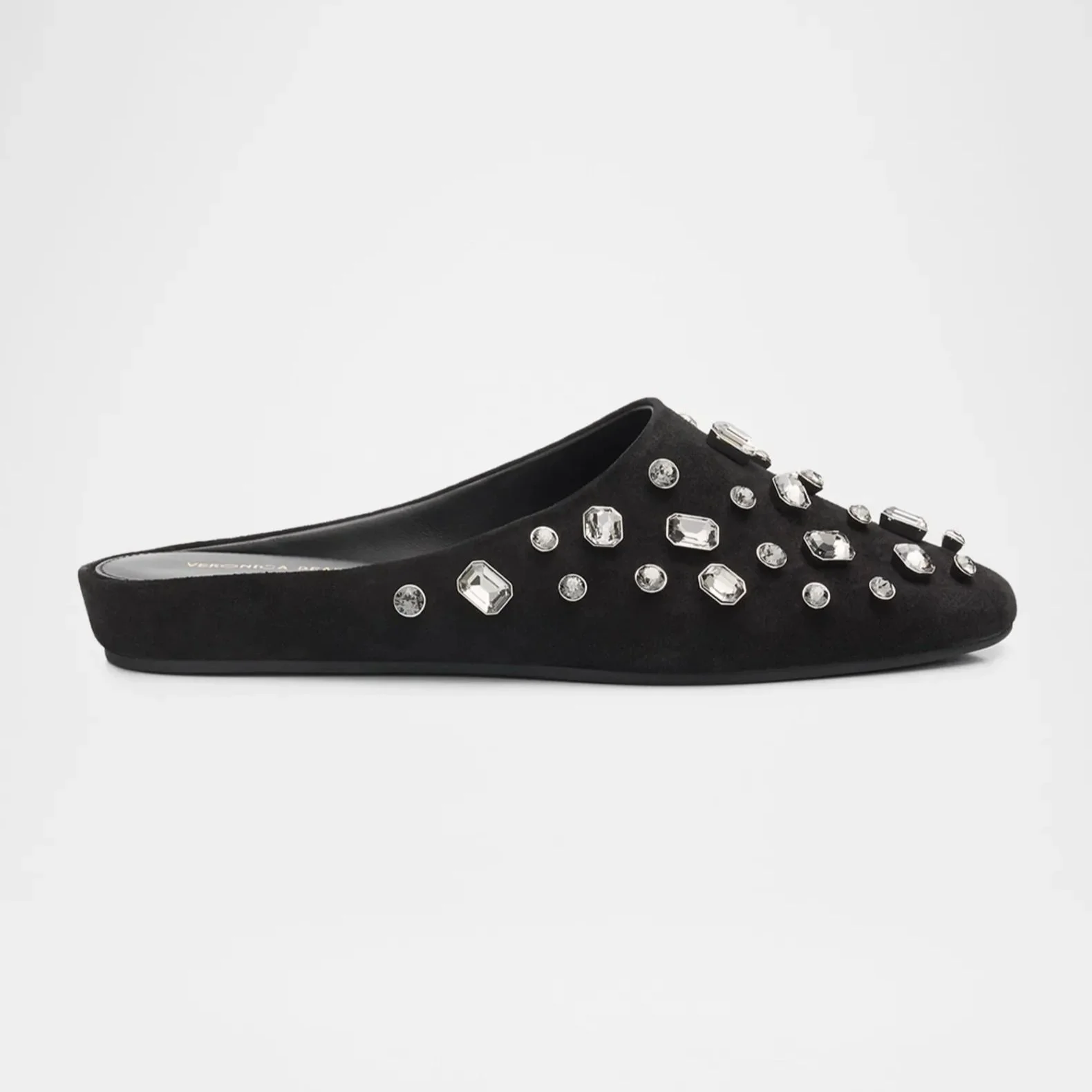Black slip-on shoe decorated with clear gemstone embellishments on a white background.