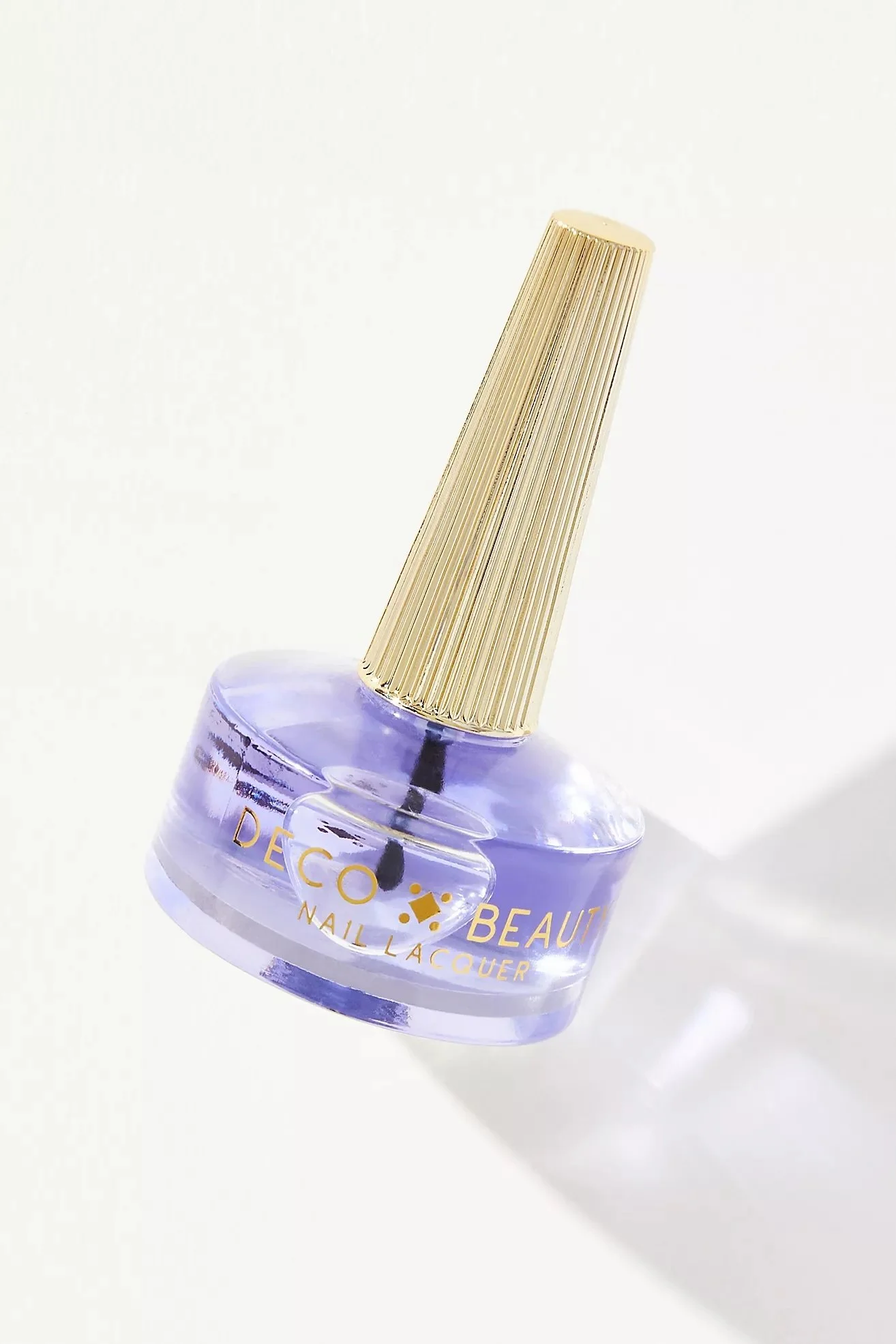Purple nail lacquer bottle with gold cap, labeled 'Deco Beauty Nail Lacquer'