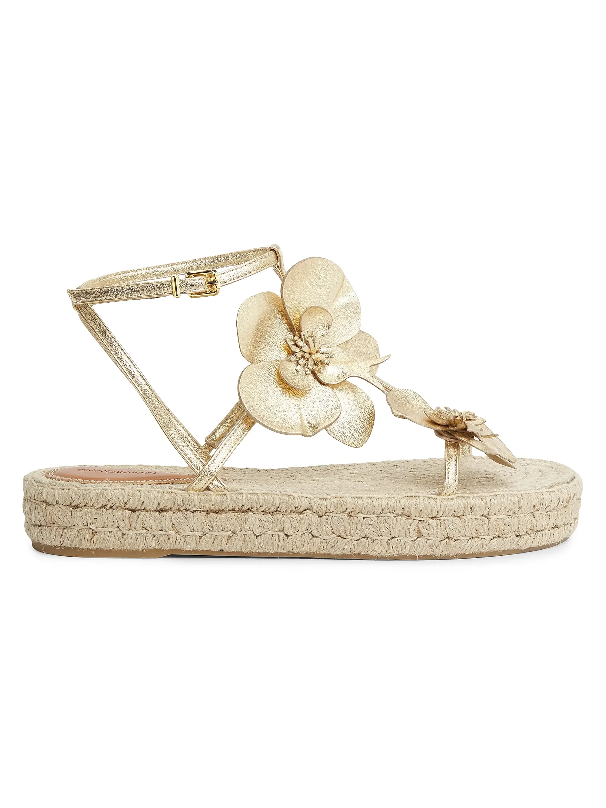 Gold sandal with floral decorations and woven sole.