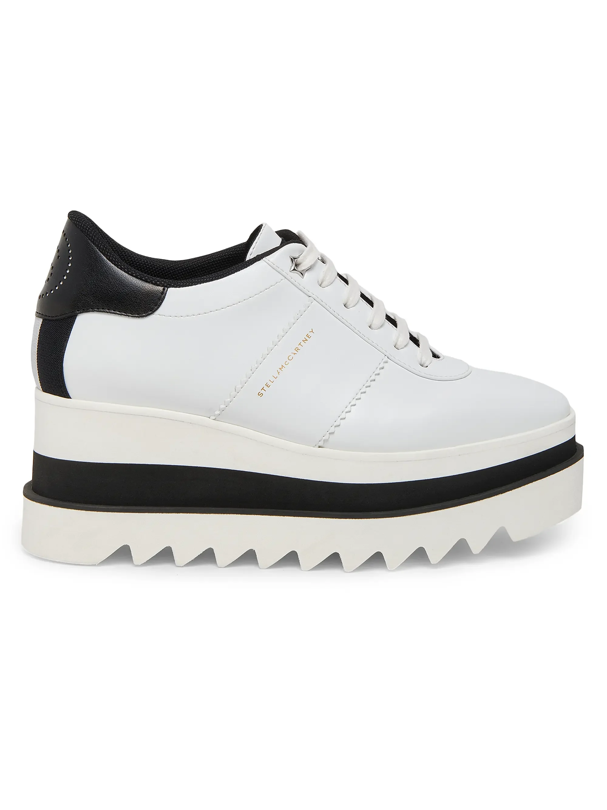 A white and black platform sneaker with a zigzag sole and gold text that says Stella McCartney on the side.
