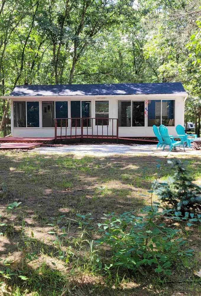 Photo of Cottage with large windows and chairs outside