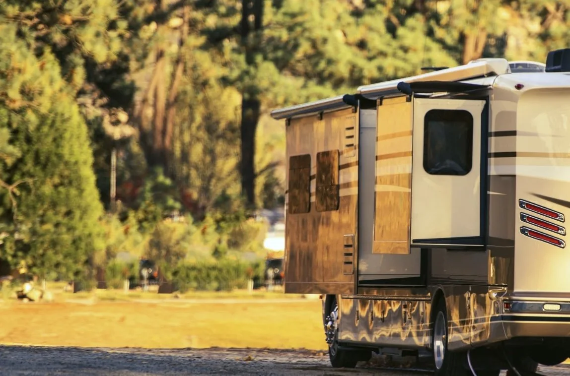 An RV. parked on a gravel site.