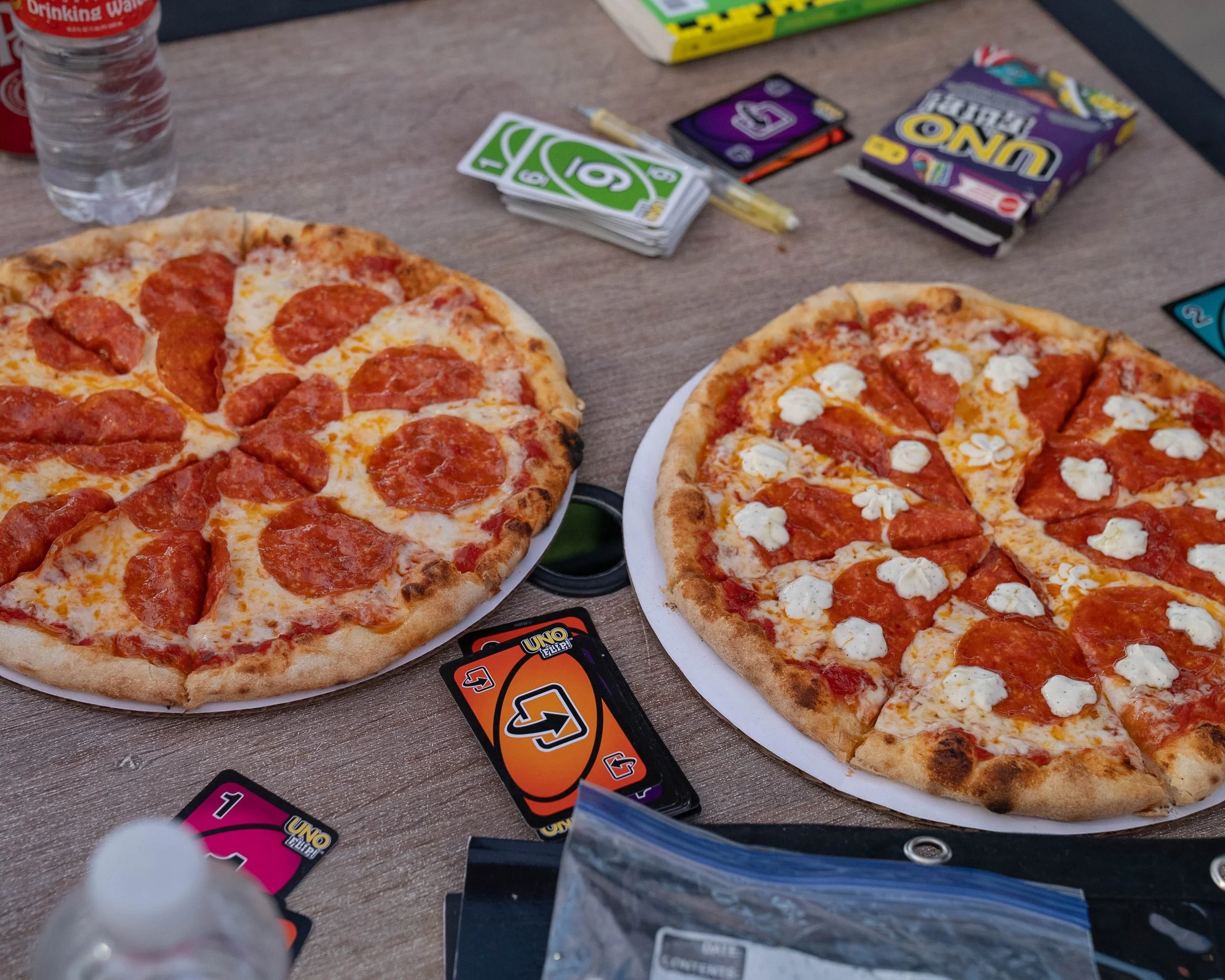 Oven Theory pizza on the patio at NEEP Collective with card games and casual hangout vibes