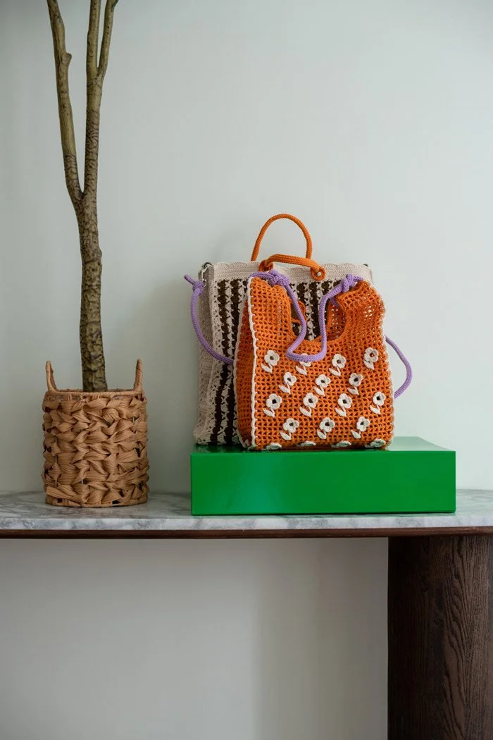 Two crocheted bags by Molla Mills on a nice side table in entry hall with KOEL Magazine.