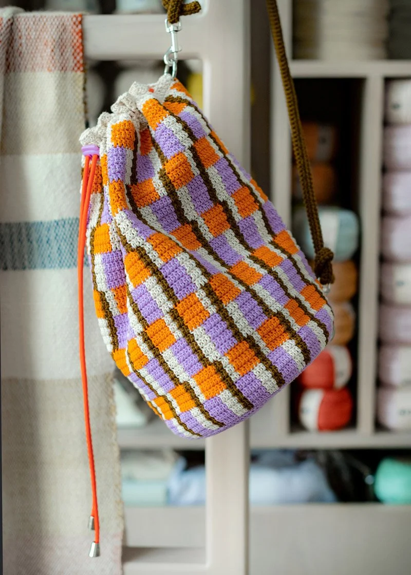 Crocheted backpack in bright spring colors by Molla Mills, orange purple and green crochet bag pattern