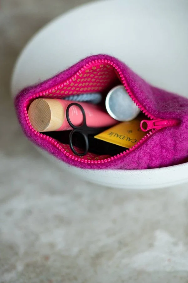 Colorful crochet pouch with zipper in Ana Sebastião’s signature Kabanita stitch, blending puff stitches with vibrant yarns in this crochet pattern.