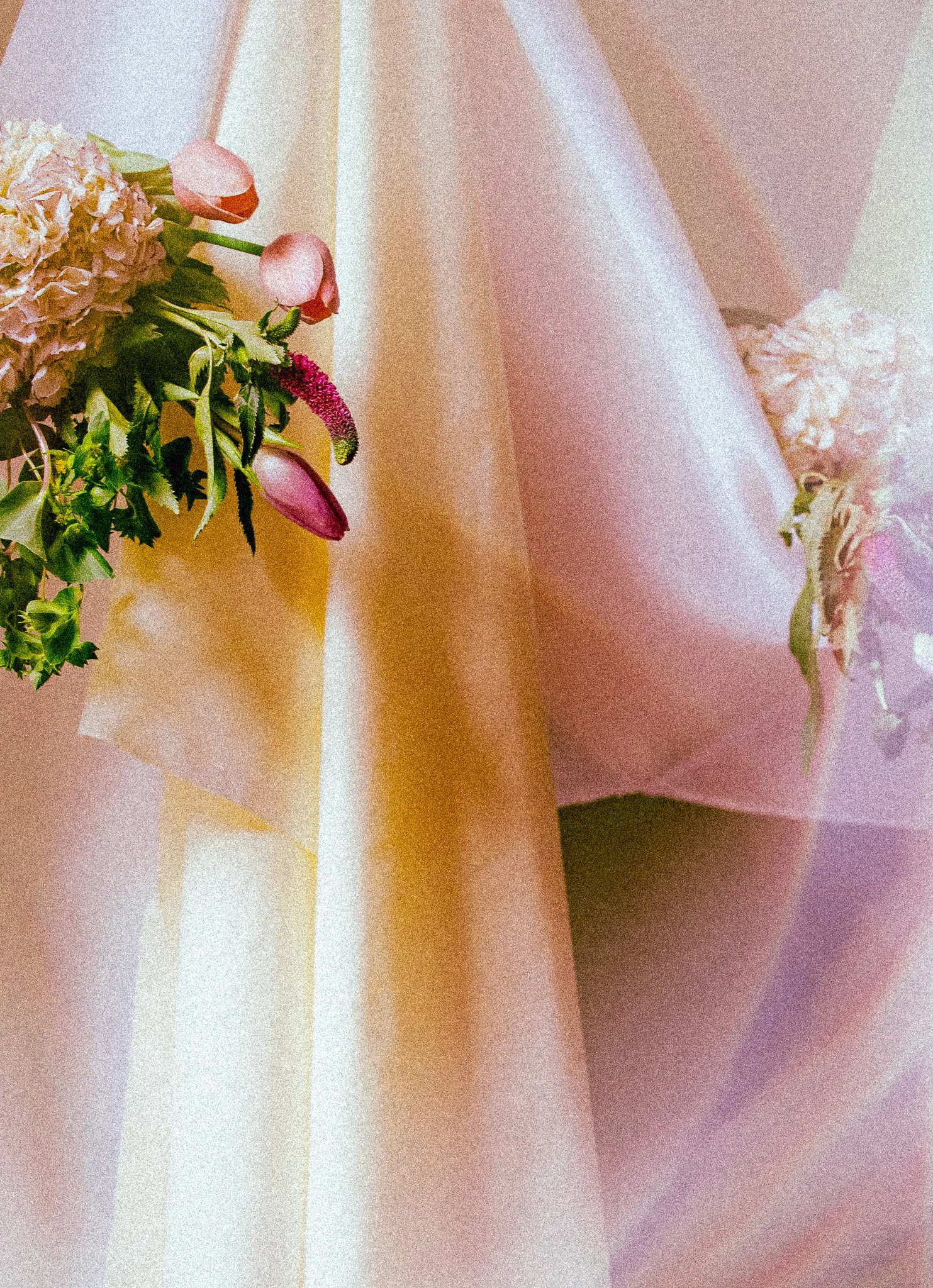 Close-up of a bouquet of pink and white flowers wrapped in pastel-colored paper.