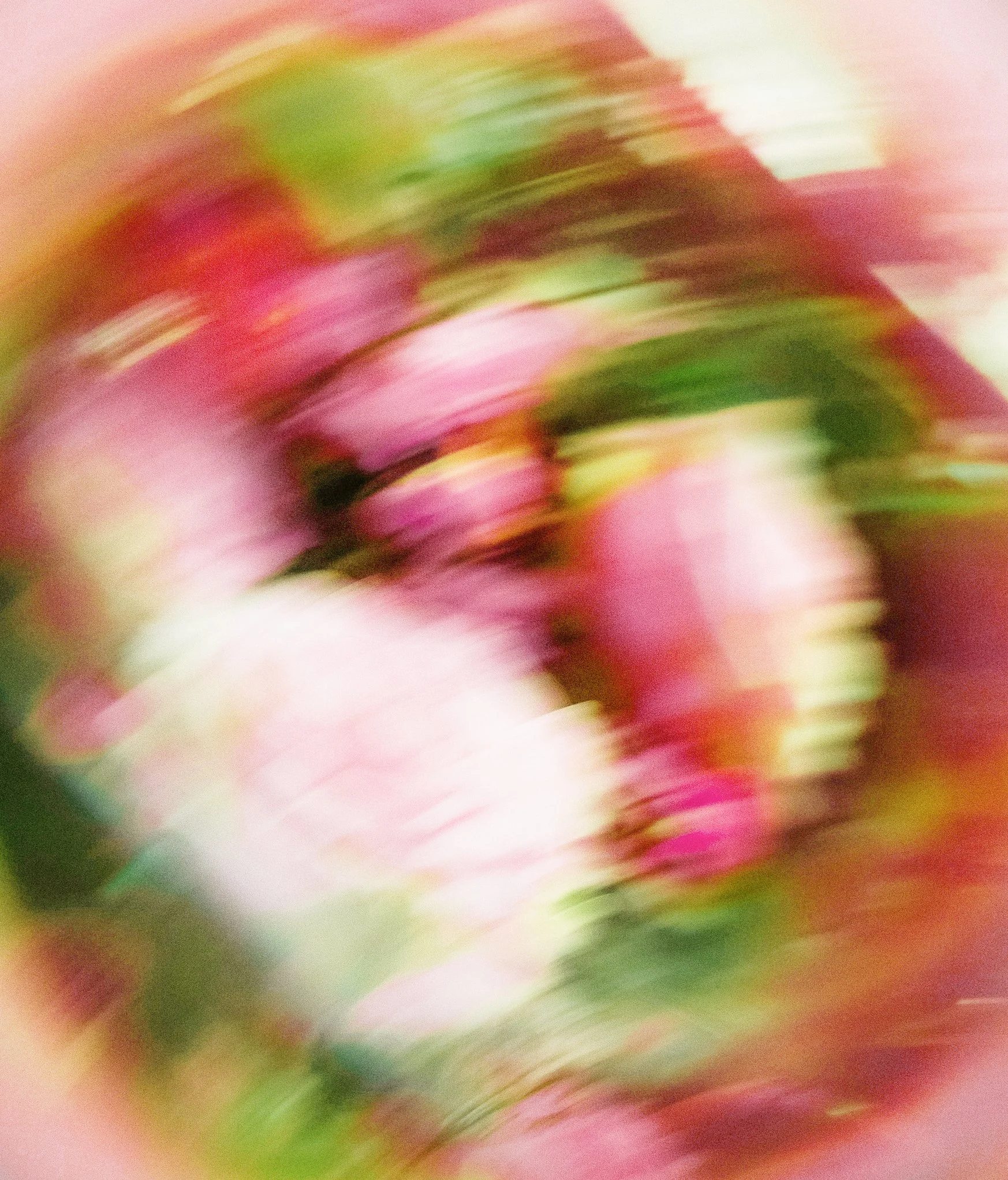 Blurred colorful abstract image with pink, green, and white hues.