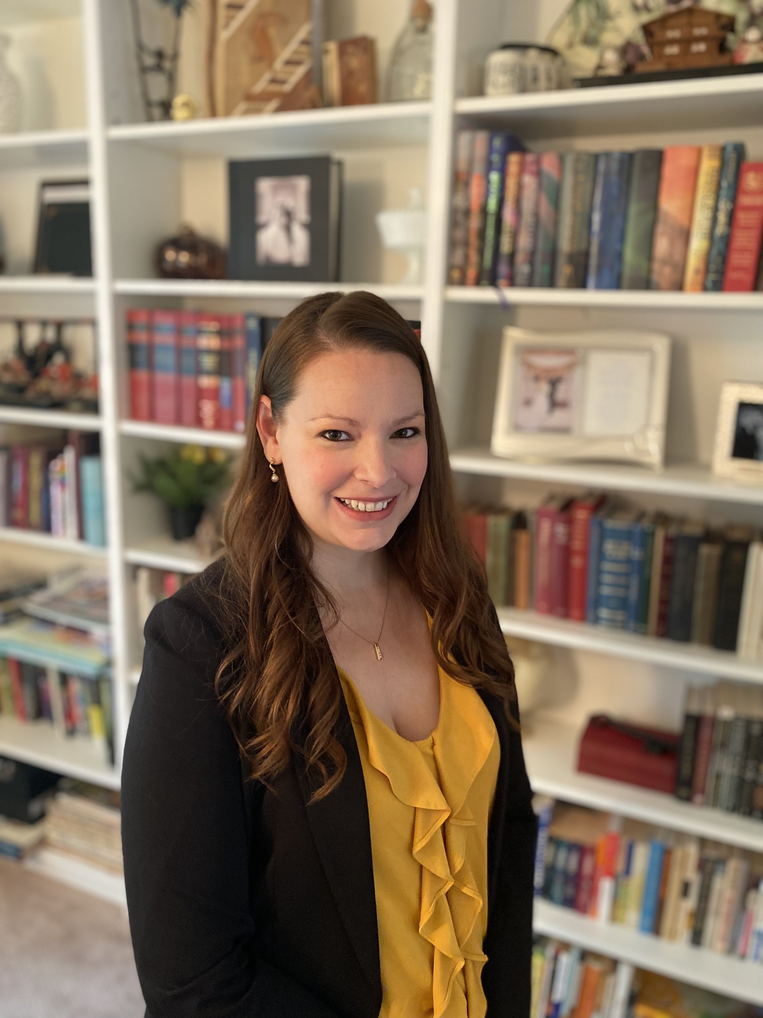 Samantha Lysk smiling in office with bookshelf background