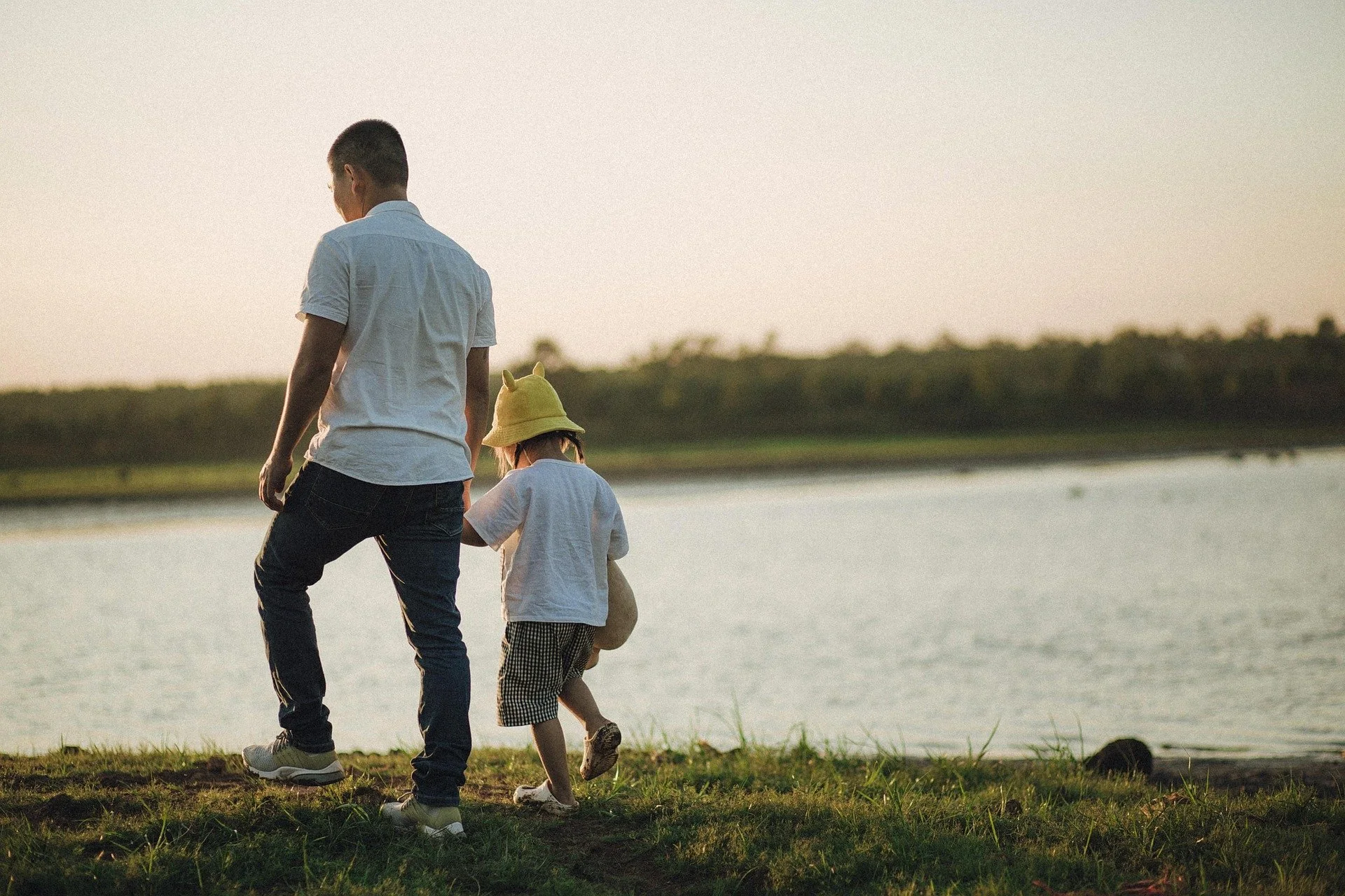 Father and child walking by lake symbolizing custody and parenting bond