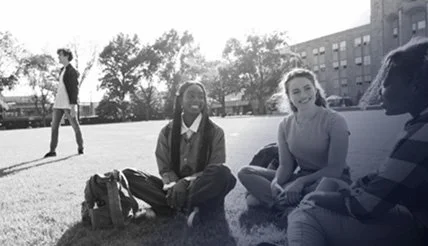 Students sitting on the lawn.