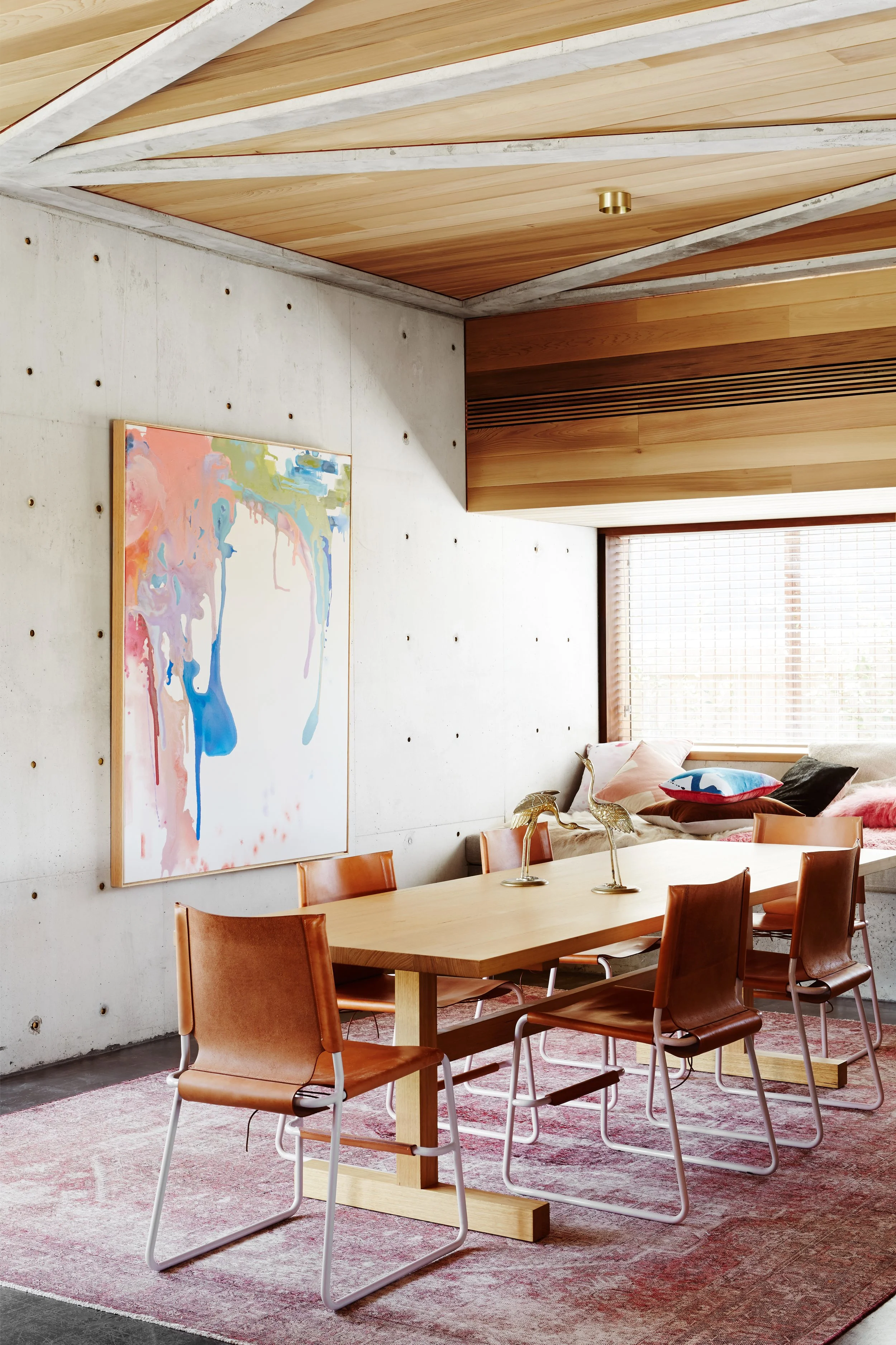 Dining room with concrete walls and timber ceiling