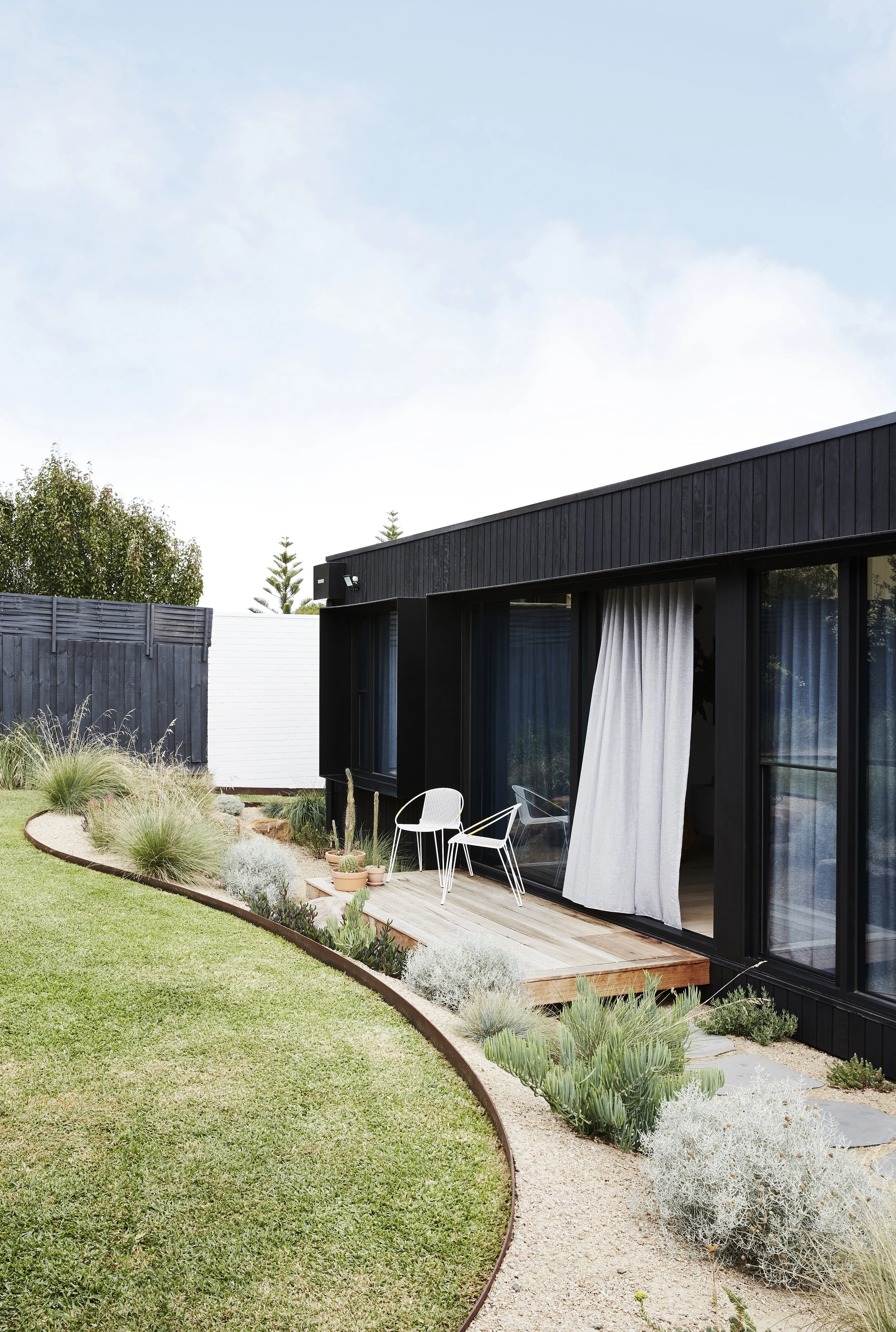 Home exterior with linen curtains and backyard