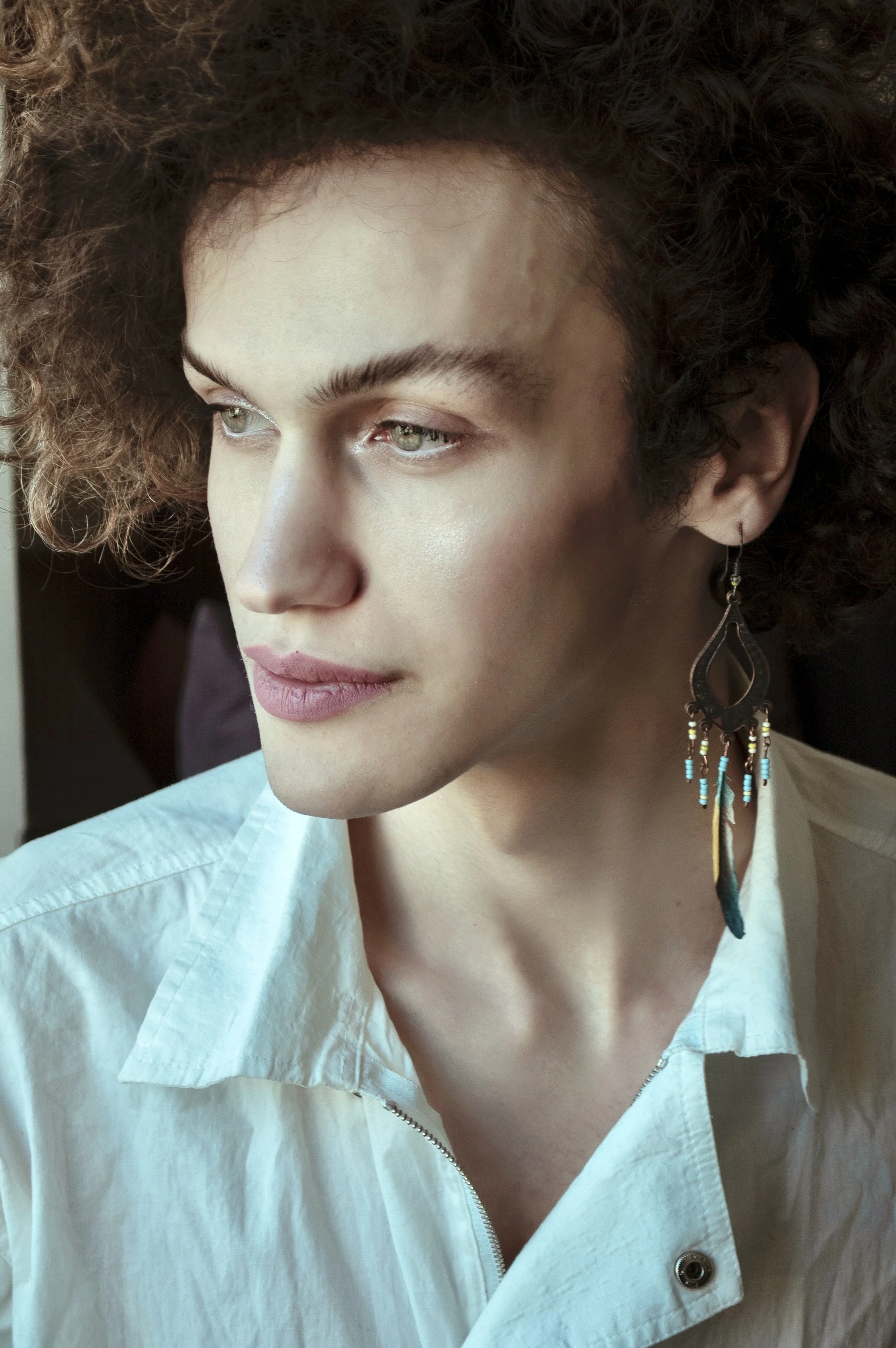 person looking into distance wearing beautiful long earring