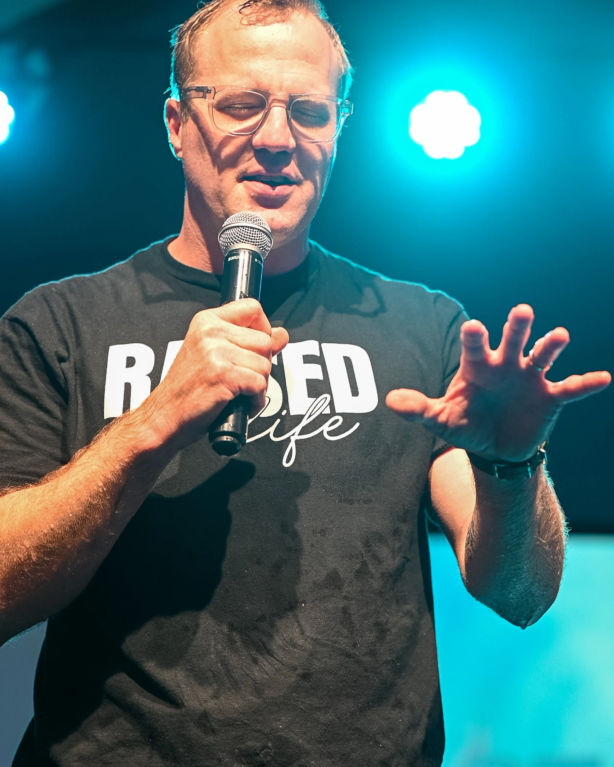 Pastor Seth Goldsmith, Lead Pastor at Coastal Church praying over the church during a Sunday morning service.