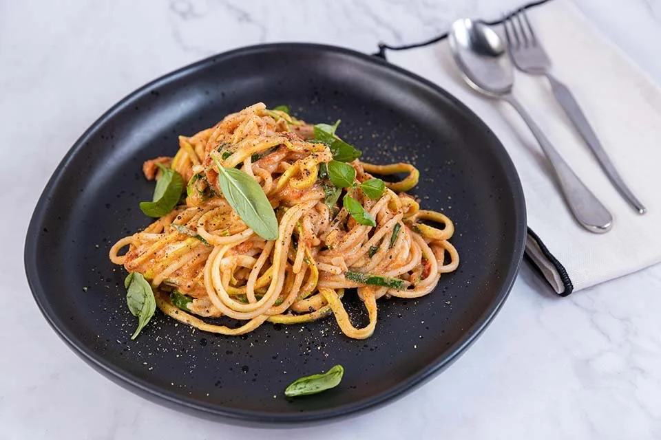 Vibrant tomato goats cheese pasta with fresh basil leaves