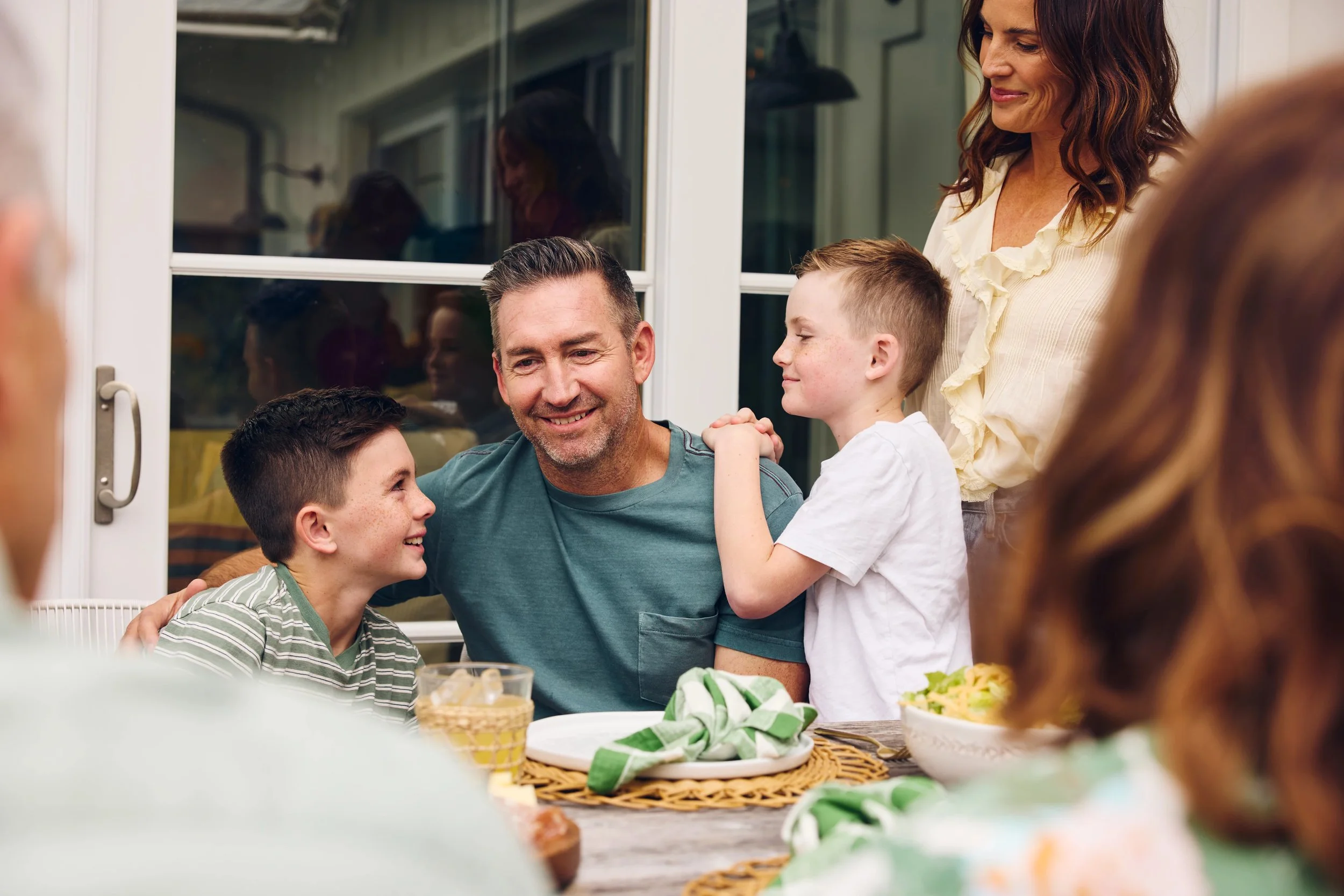 ways-to-celebrate-fathers-day-dad-with-family-around-table-outdoors.jpg
