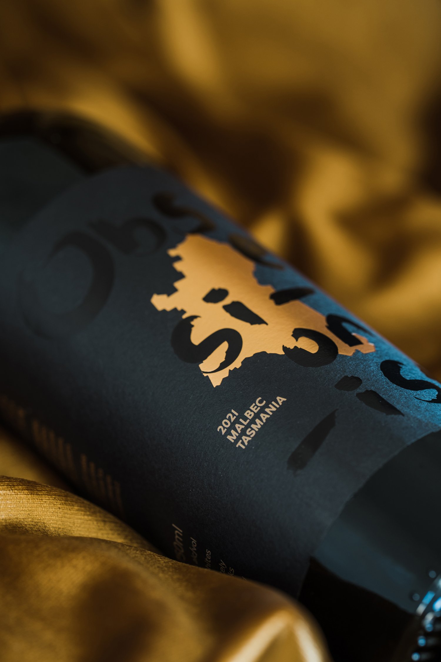 Close up of Obsessionist bottle of wine on black silk and dark background (Copy)