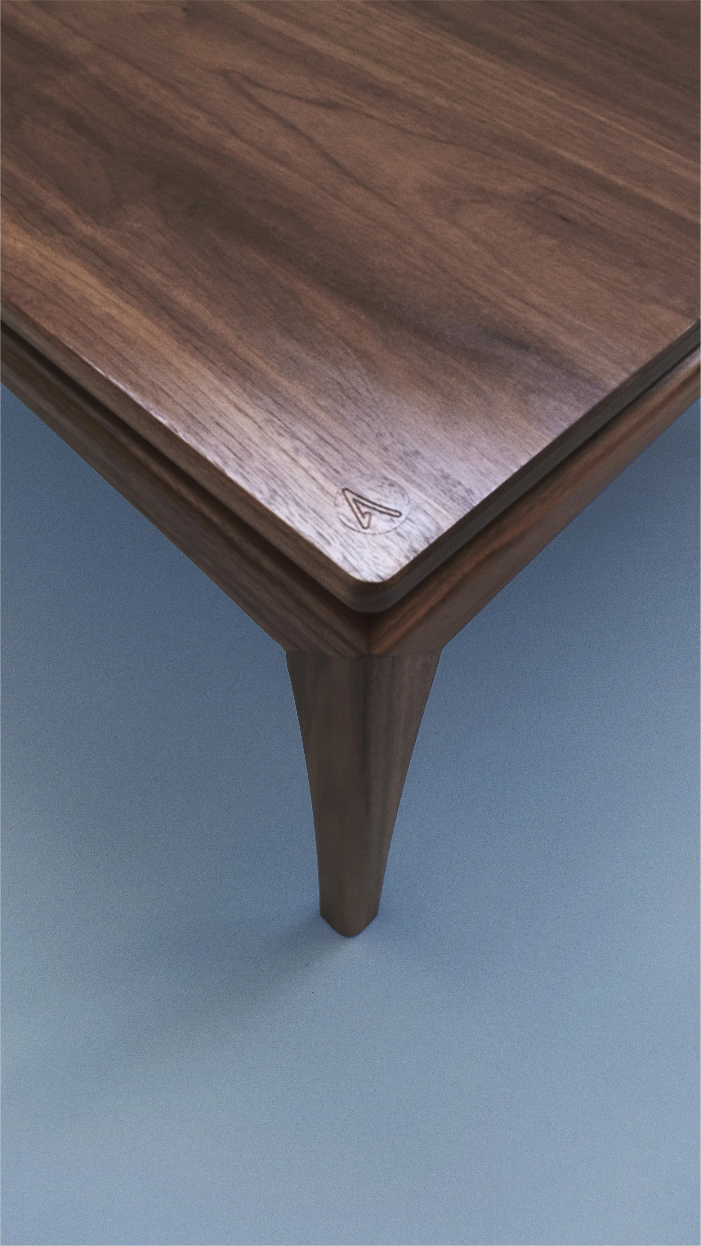 Subtle logo under which a NFC chip is hidden to give its owner an access to the full history of the table