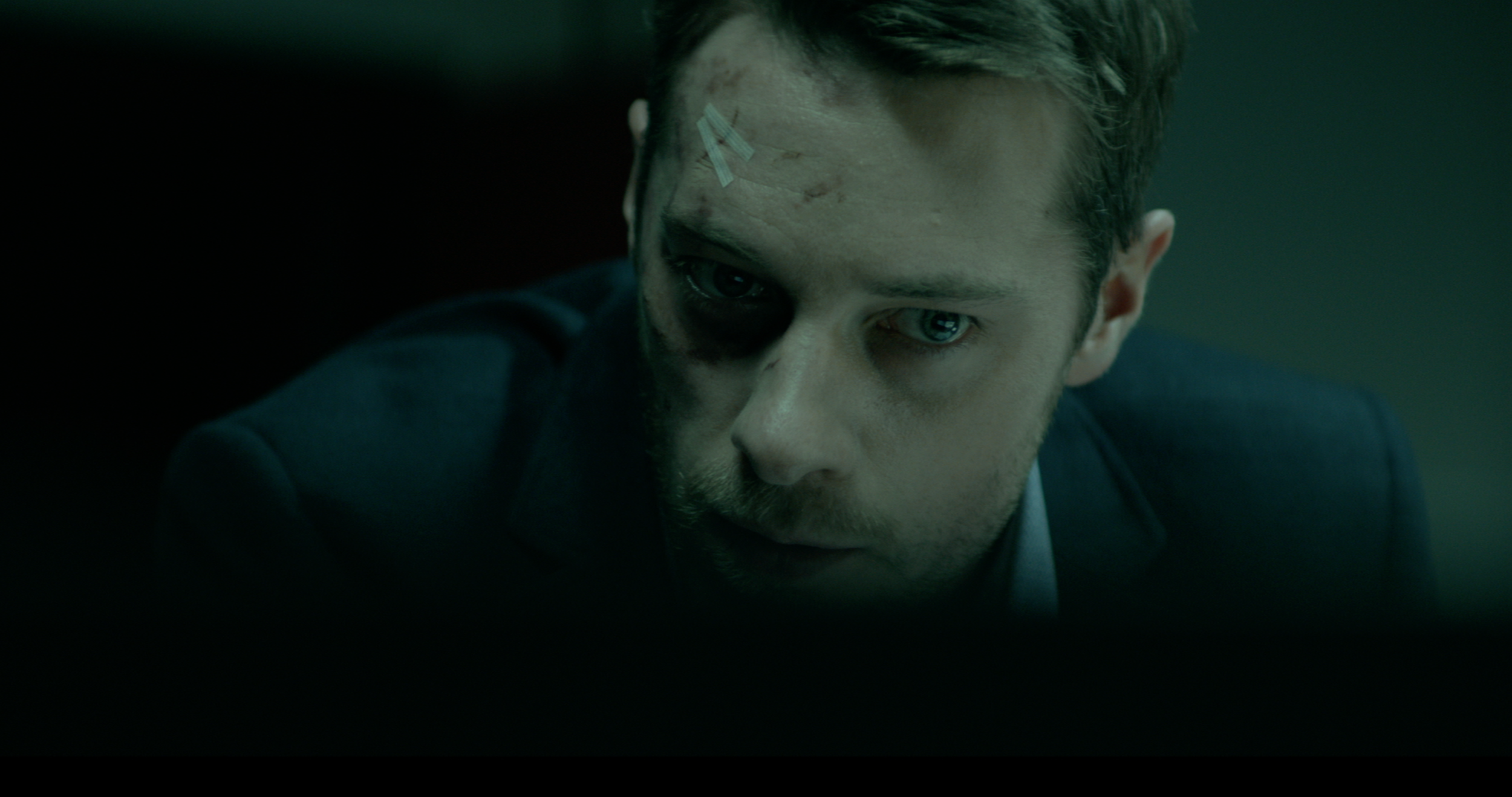 Close-up of a man in a dark interior in Occupied, cinematography by Johan-Fredrik Bødtker.