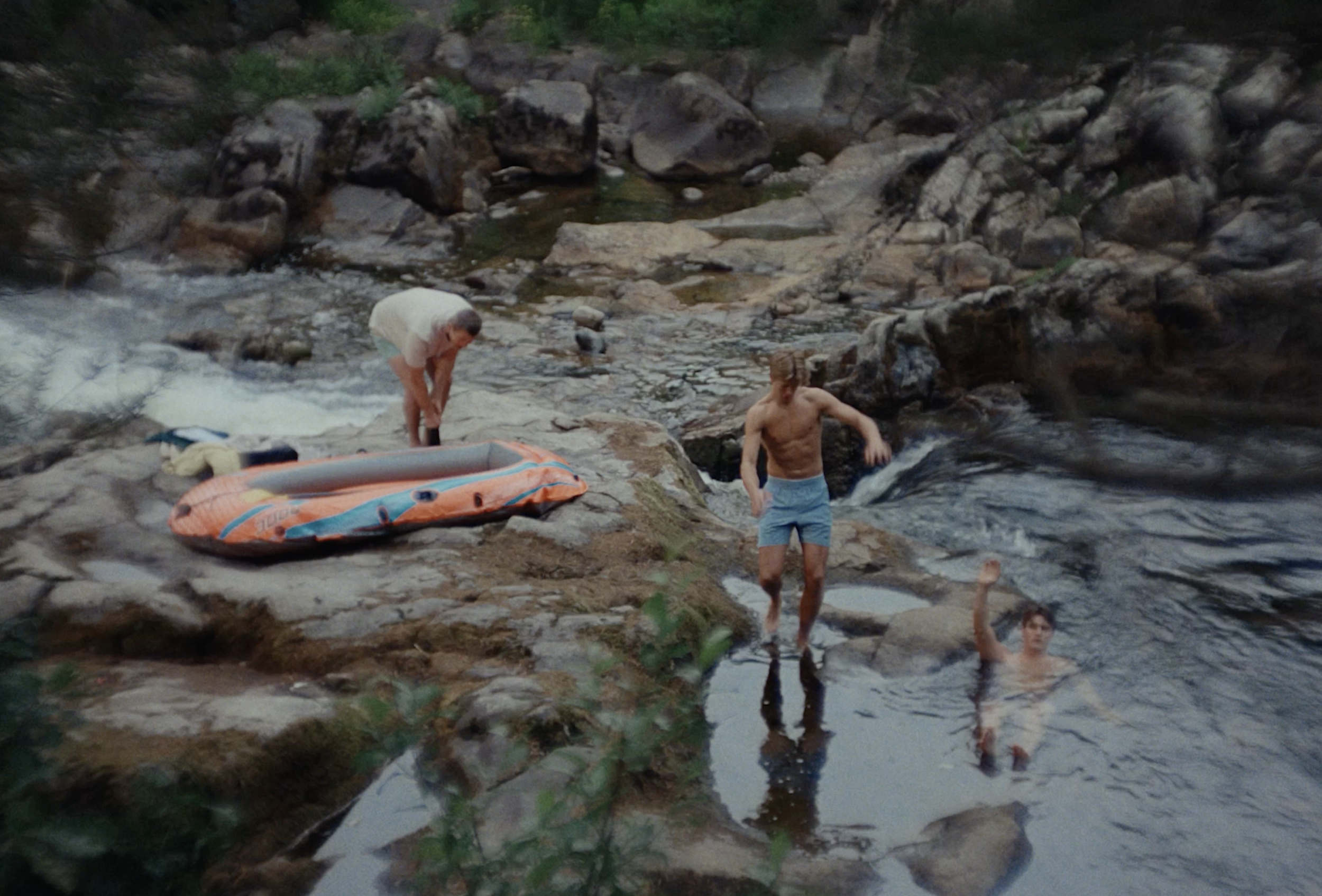 Bama commercial — two men by a rocky river with a small inflatable boat.