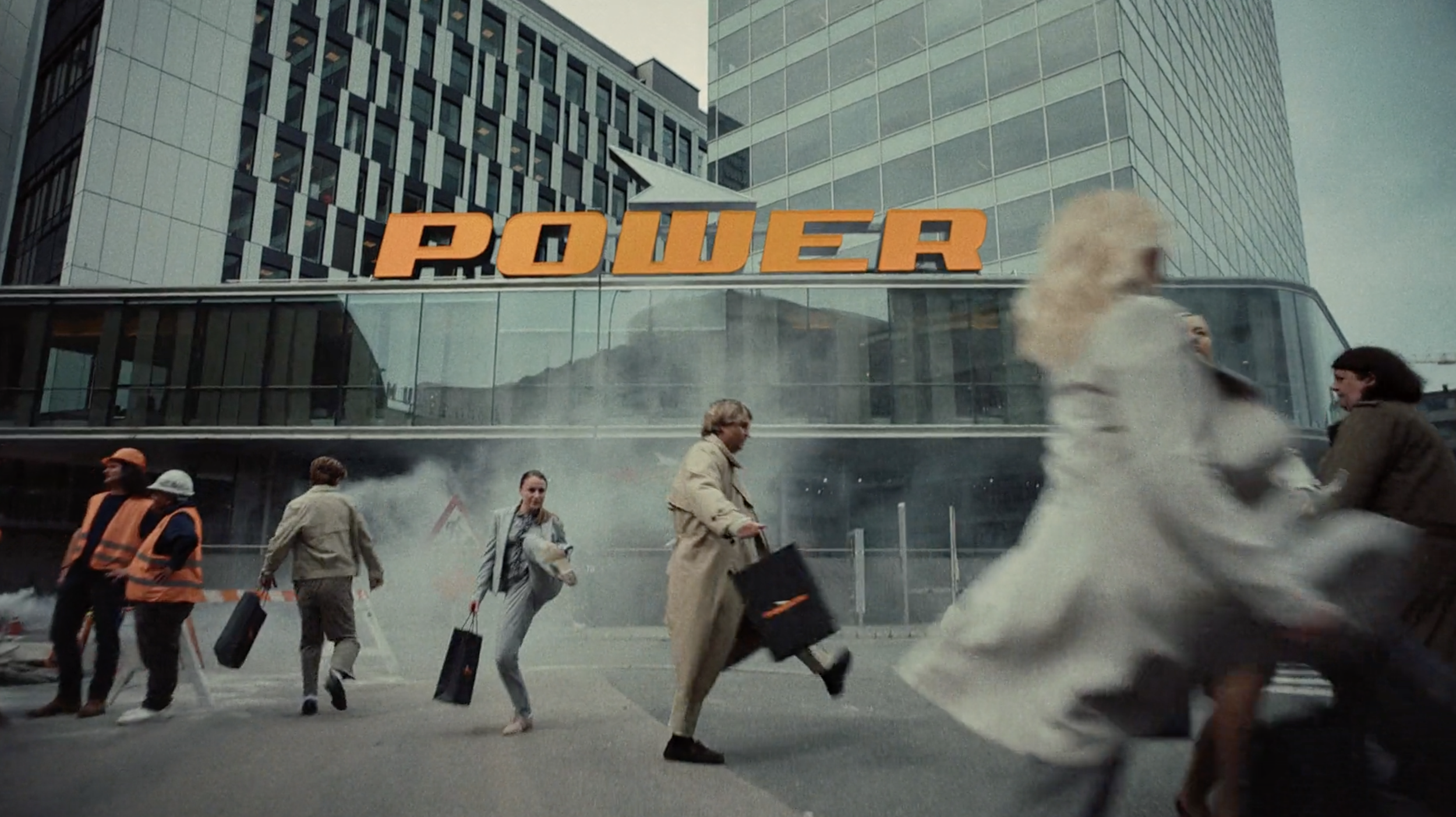 People moving outside a Power store in an energetic commercial scene, cinematography by Johan-Fredrik Bødtker.