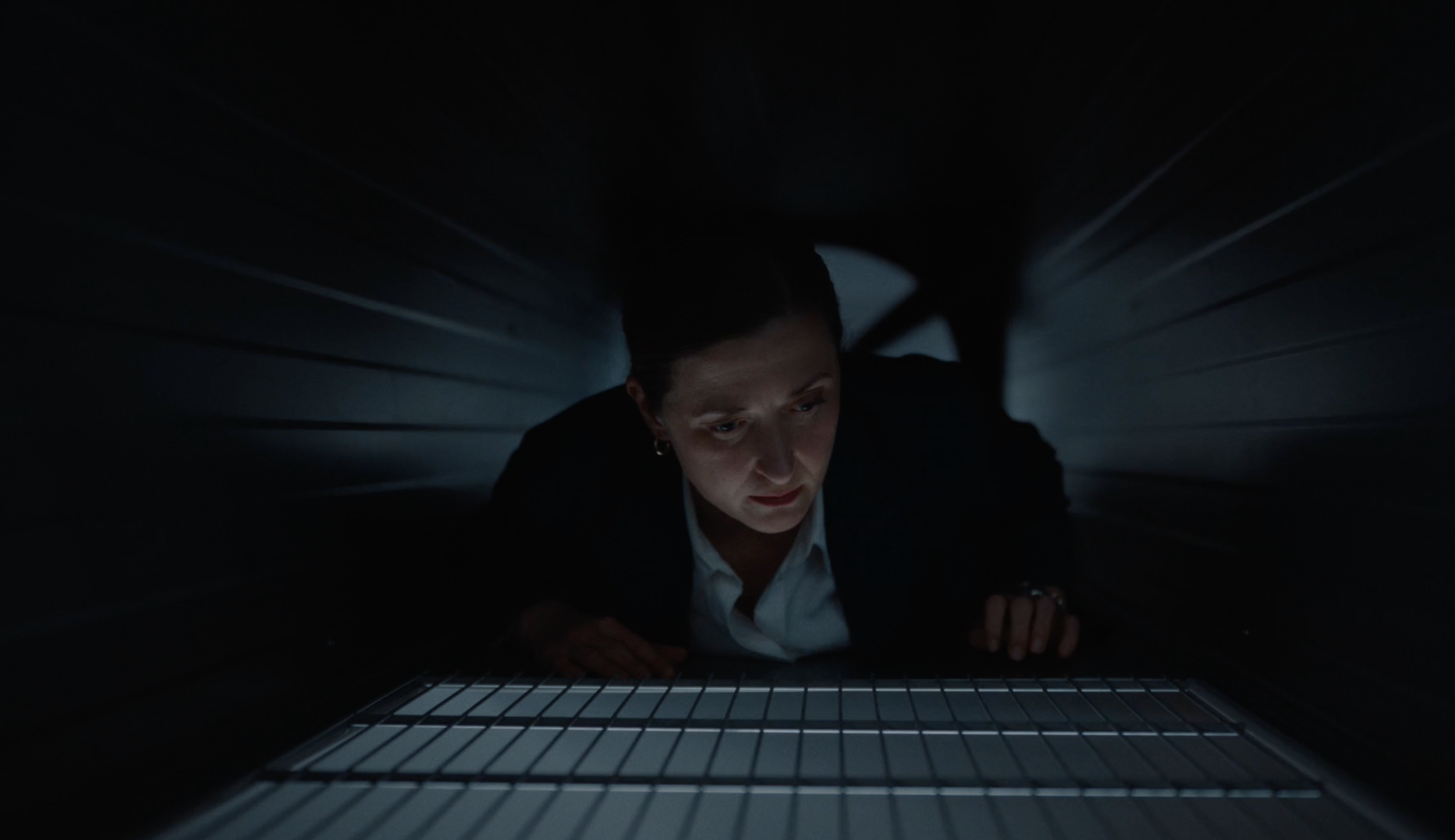 Woman tapped in ventilation shaft in a dark scene from a PowerOffice commercial, cinematography by Johan-Fredrik Bødtker.