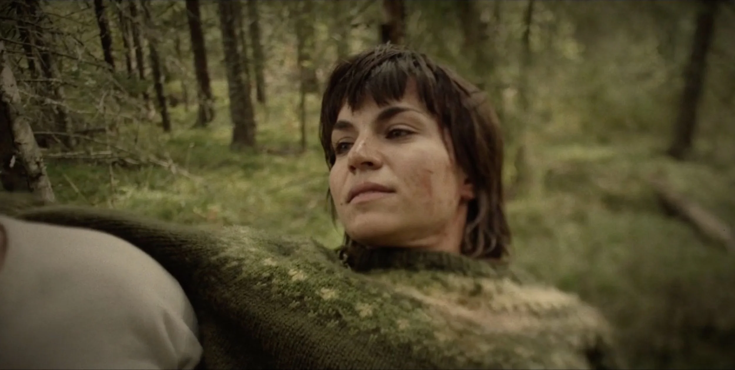 Woman lying on the forest floor in Fenris, cinematography by Johan-Fredrik Bødtker.