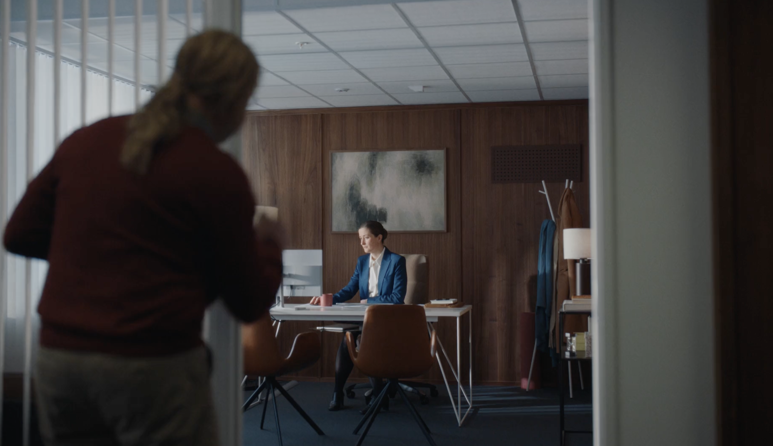 Woman seated at a desk in a modern office in a PowerOffice commercial, cinematography by Johan-Fredrik Bødtker.