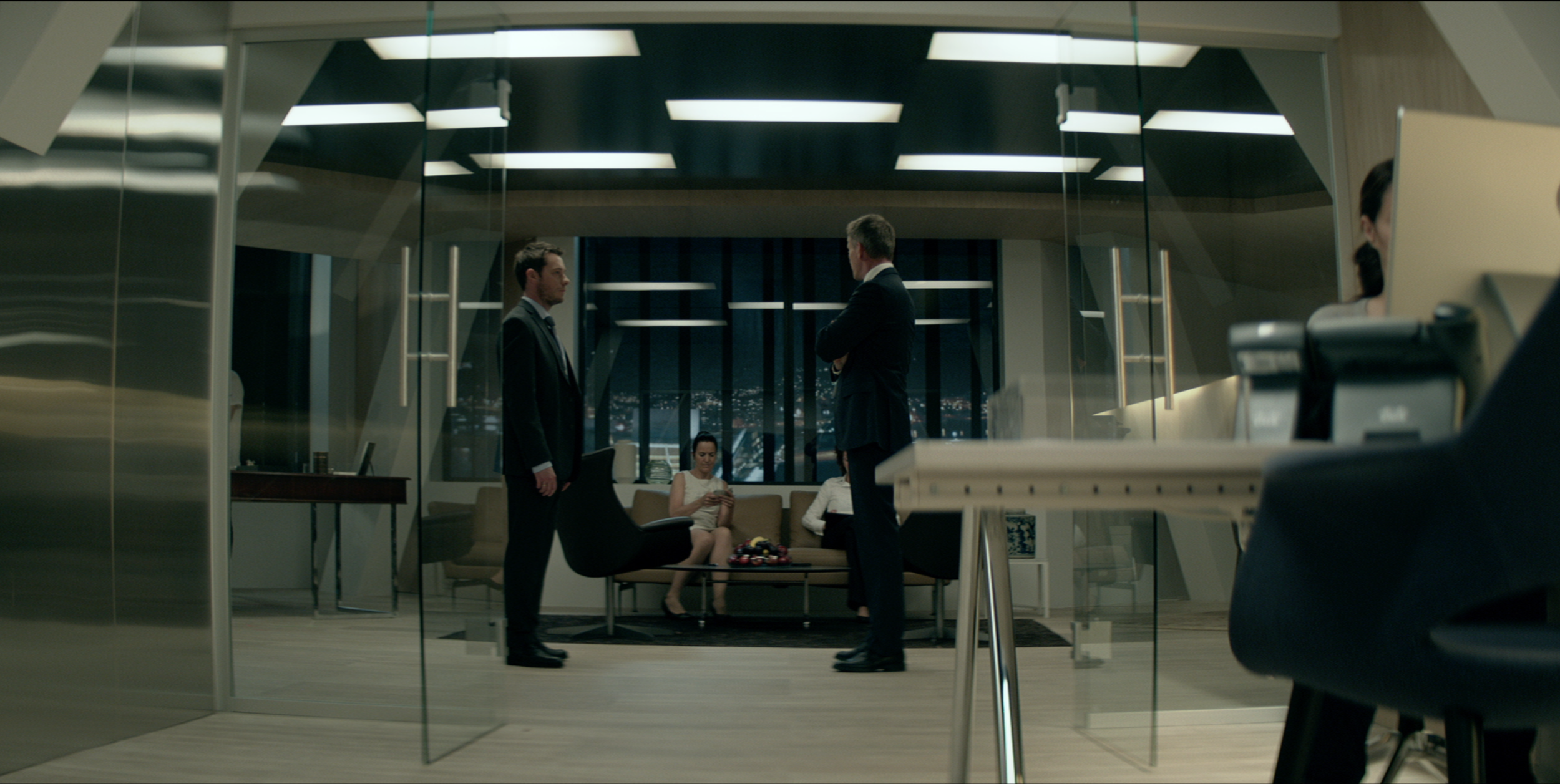Men standing in a modern office interior in Occupied, cinematography by Johan-Fredrik Bødtker.