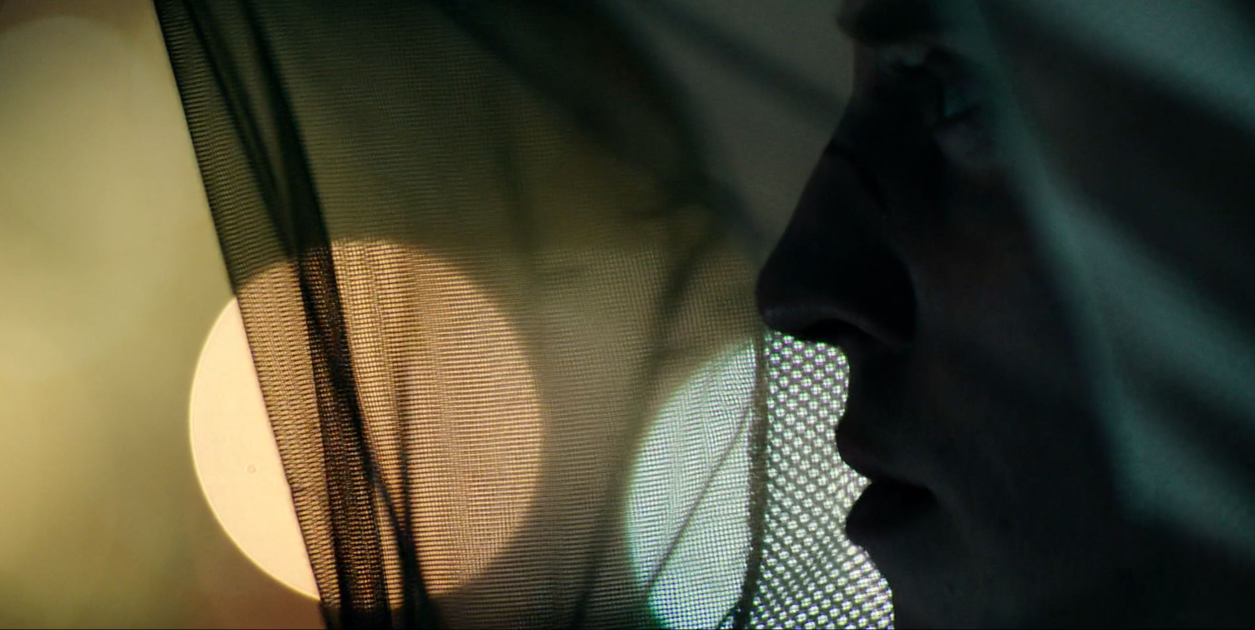 Profile of a man silhouetted against a round light in Valkyrien, cinematography by Johan-Fredrik Bødtker.