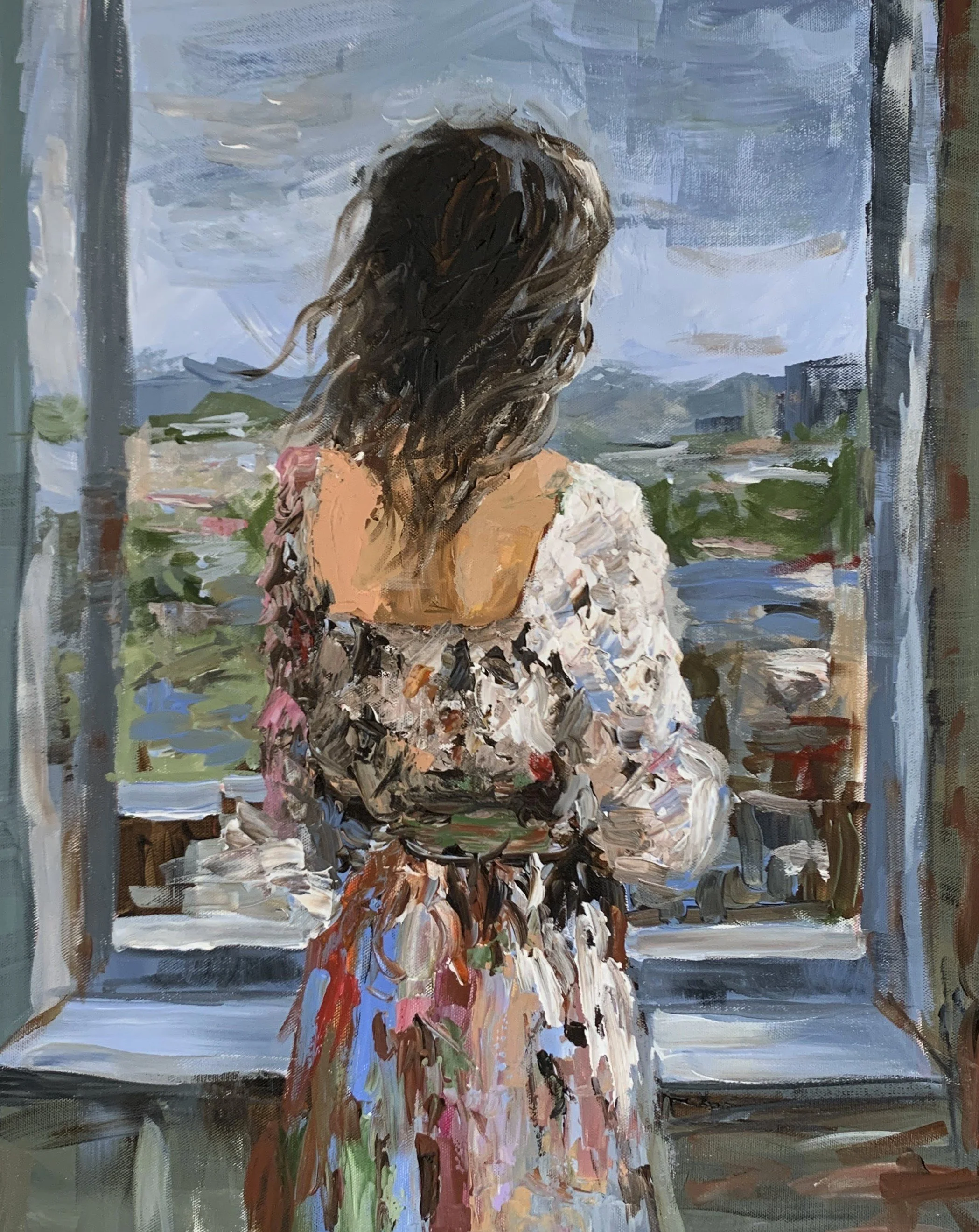 Woman in a loose floral dress seen from behind at an open window overlooking green landscape Vita Schagen
