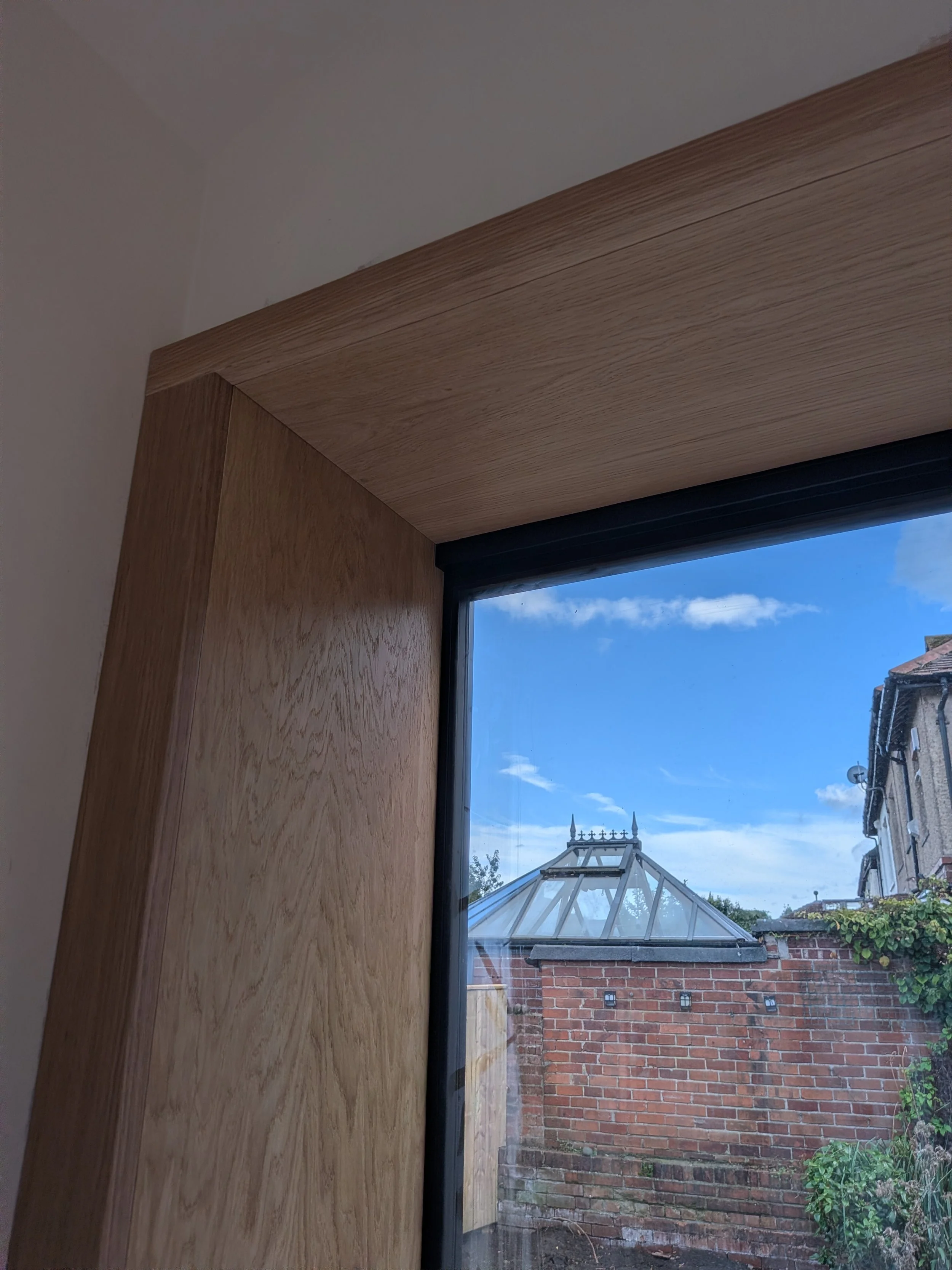 Oak window seat and surround with integrated bookcase installed in a new kitchen extension in Tynemouth. 