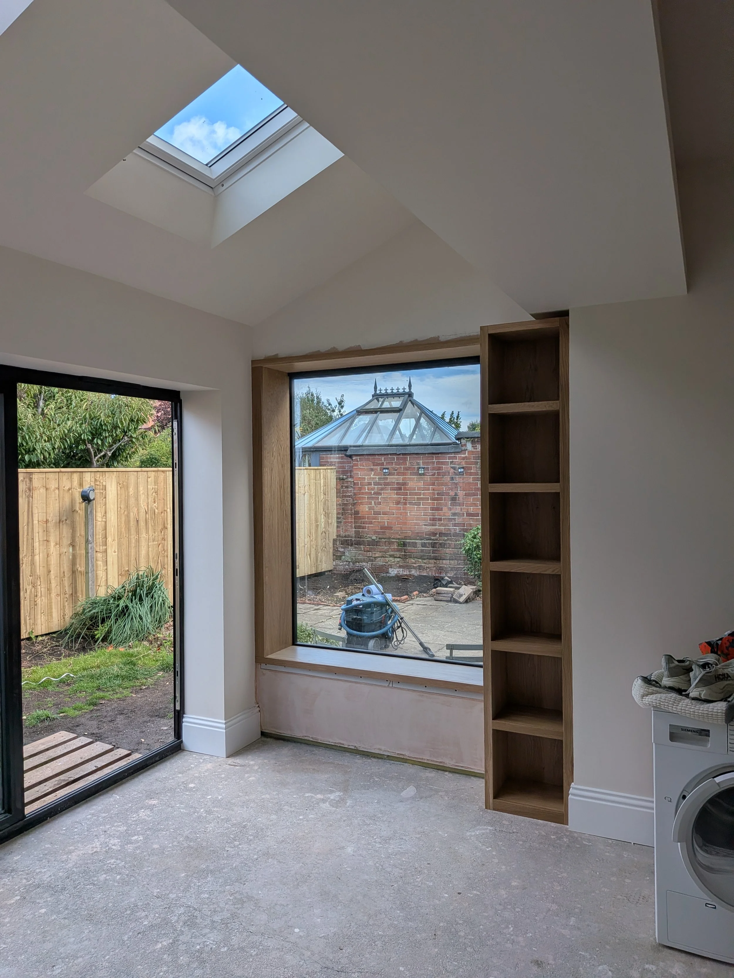 Oak window seat and surround with integrated bookcase installed in a new kitchen extension in Tynemouth. 