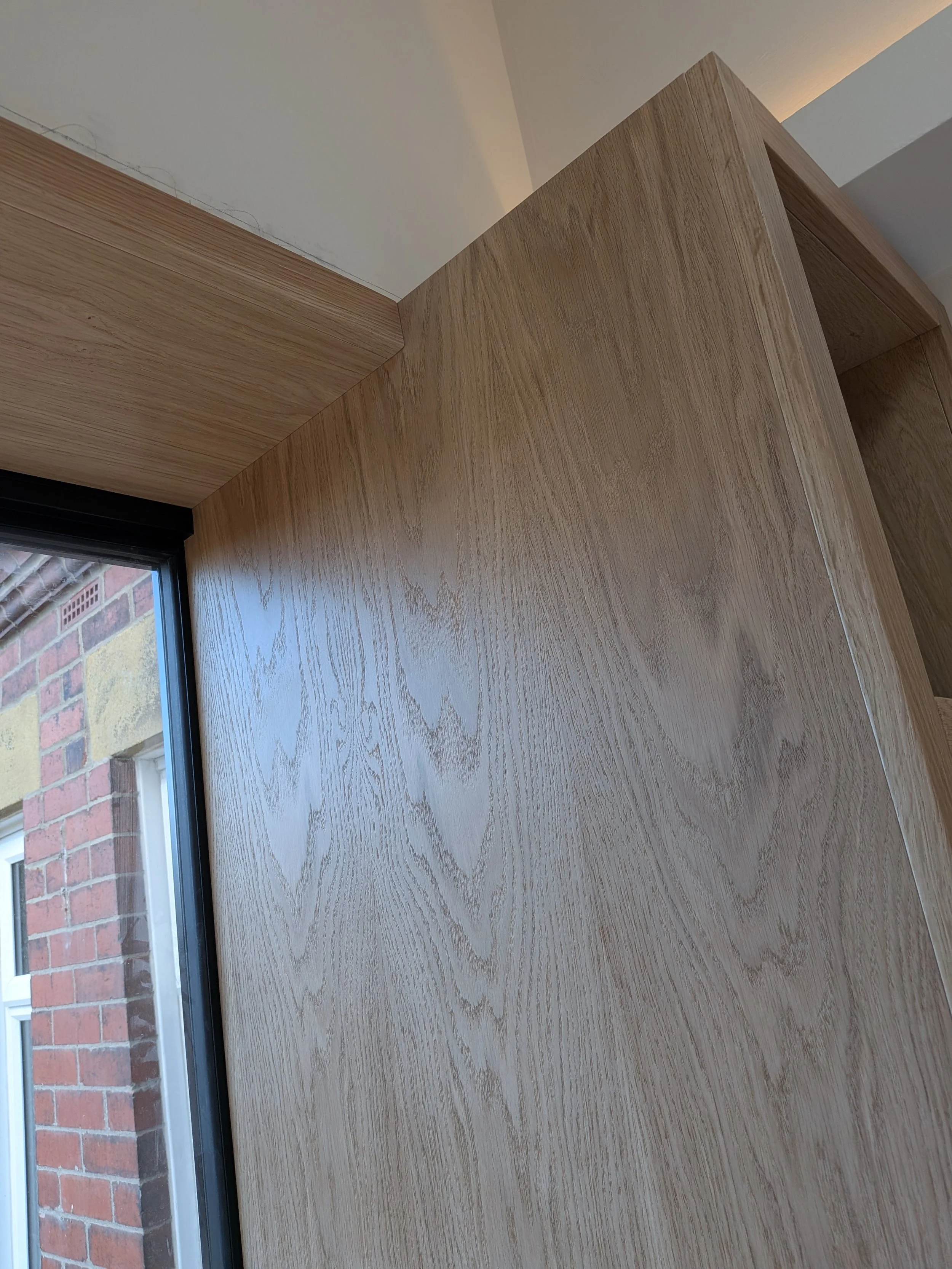 Oak window seat and surround with integrated bookcase installed in a new kitchen extension in Tynemouth. 