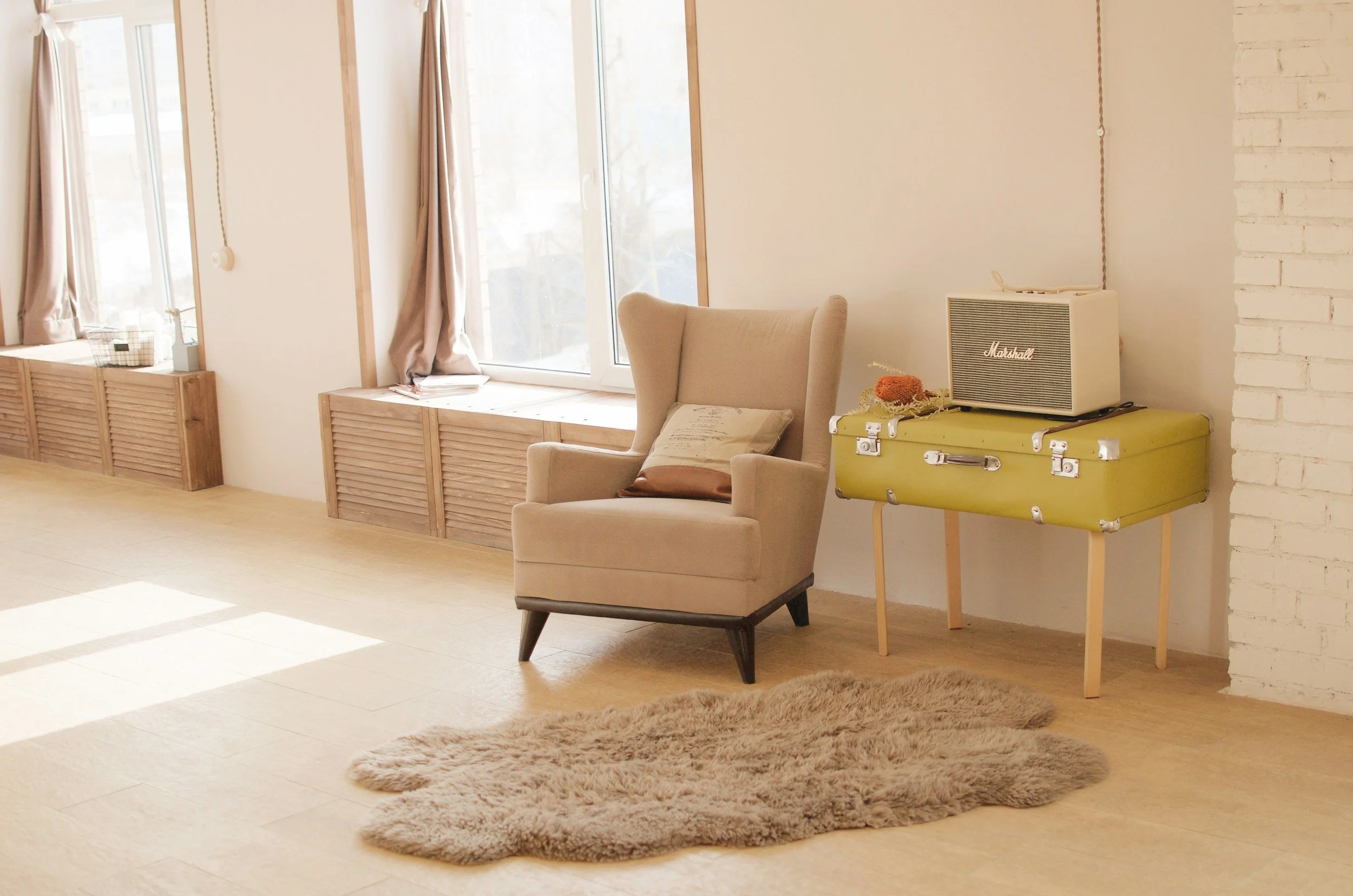 A cozy living room corner with beige armchair that is perfect for having a confidential therapy session.
