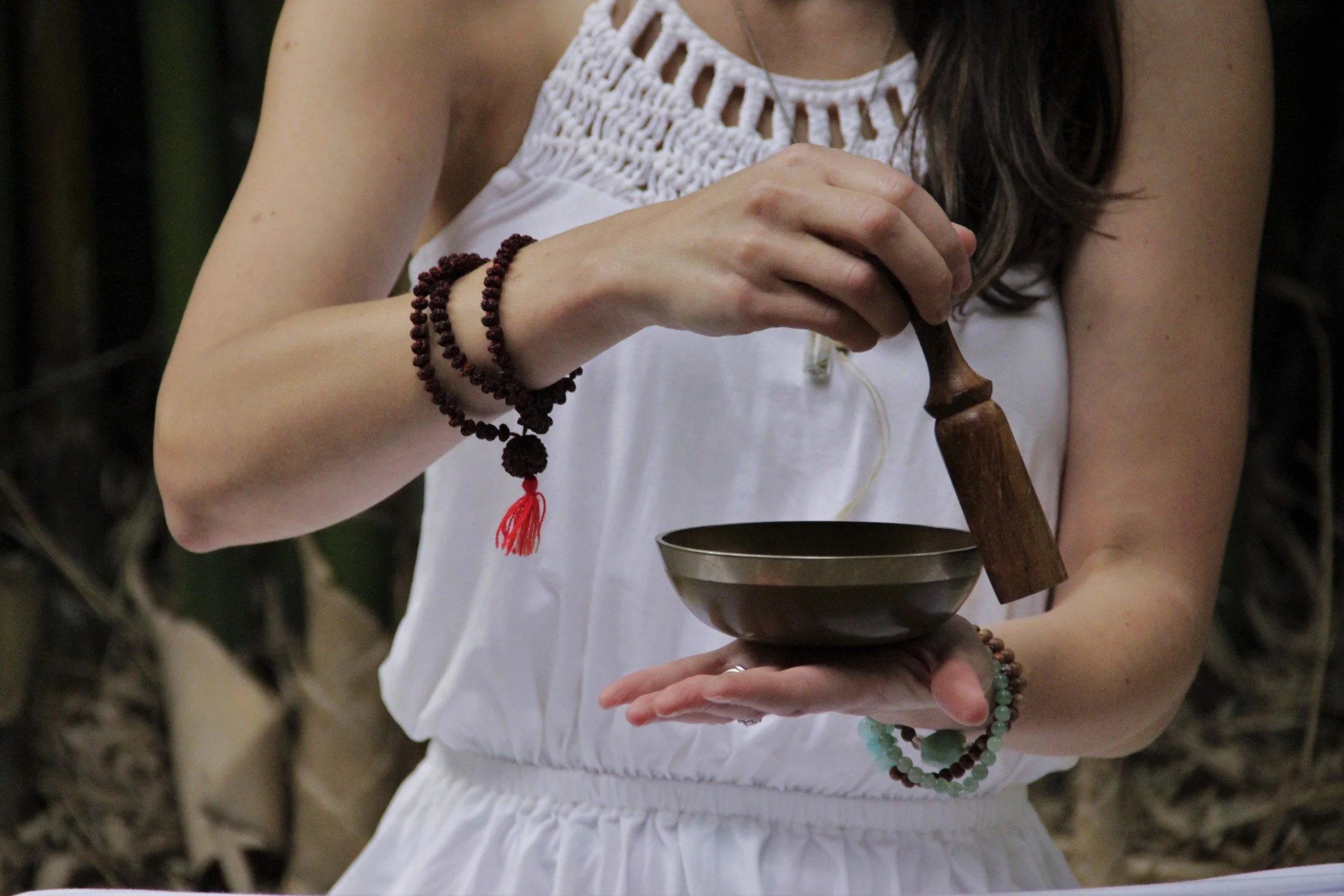 Close up of a woman's hands holding a Tibetan singing bowl.
