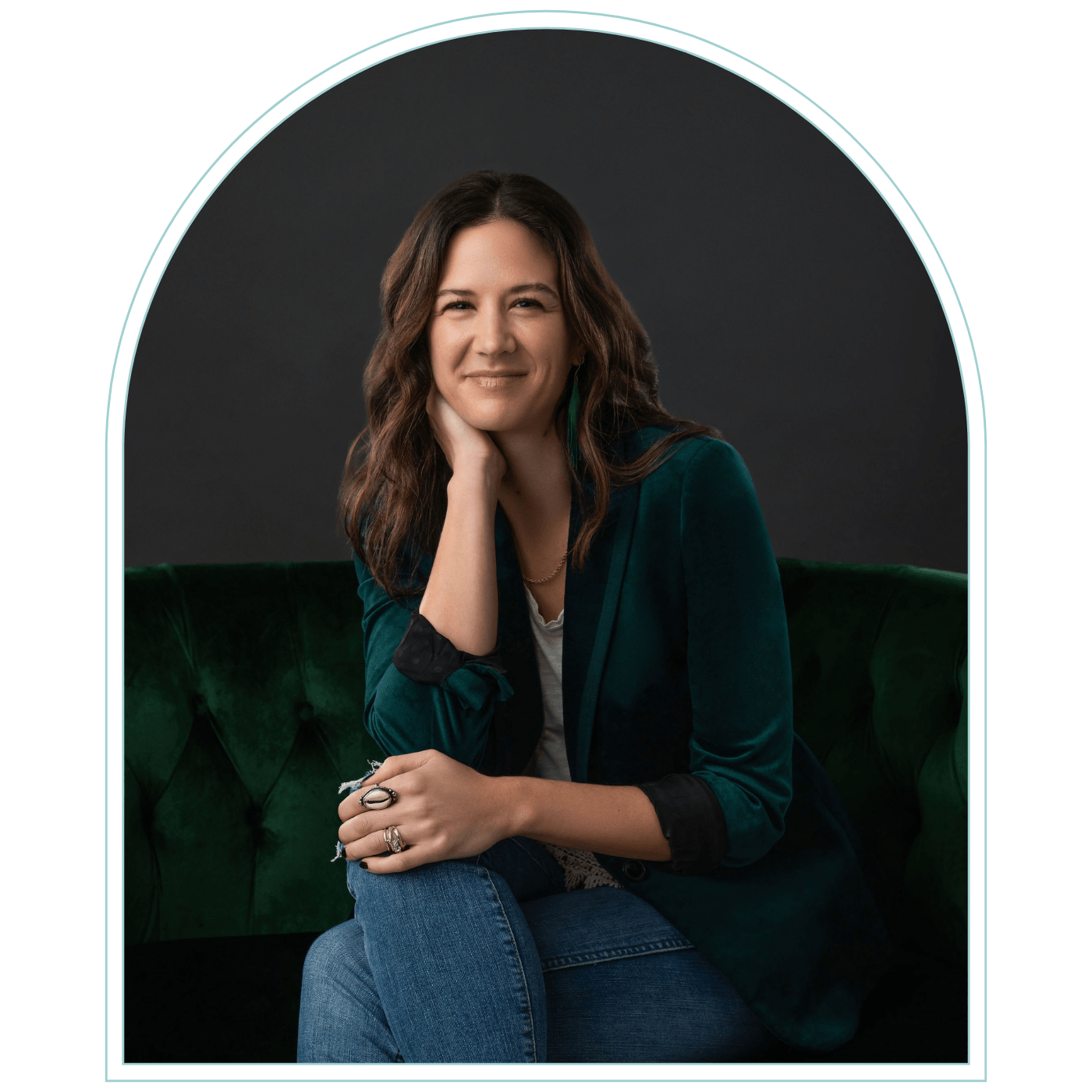 Headshot of Genevieve Camp sitting on a green velvet couch.