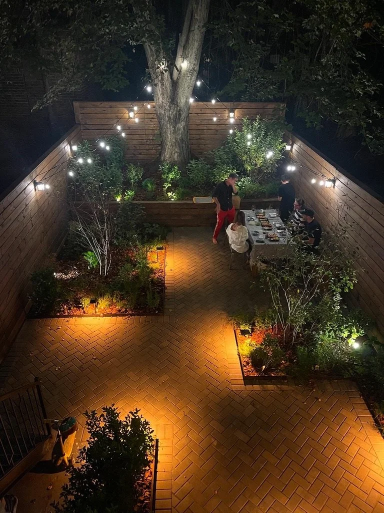 Custom paver stone patio and fencing, garden beds, and string lighting system