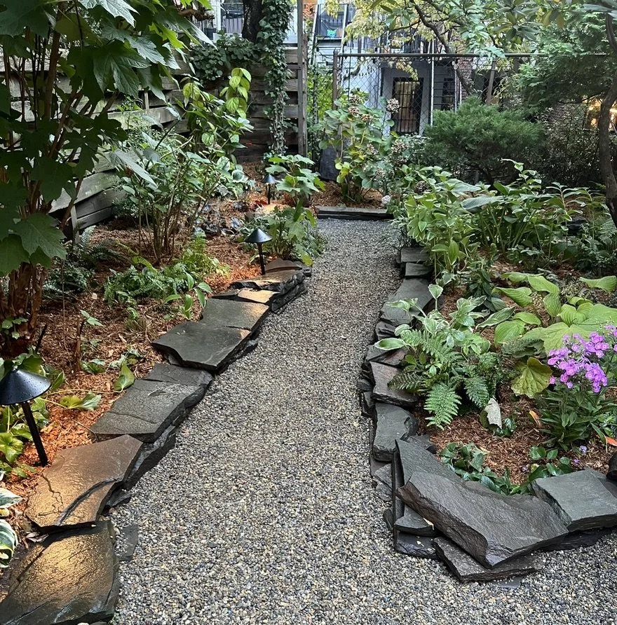 Garden lights, gravel walkway, and stone wall