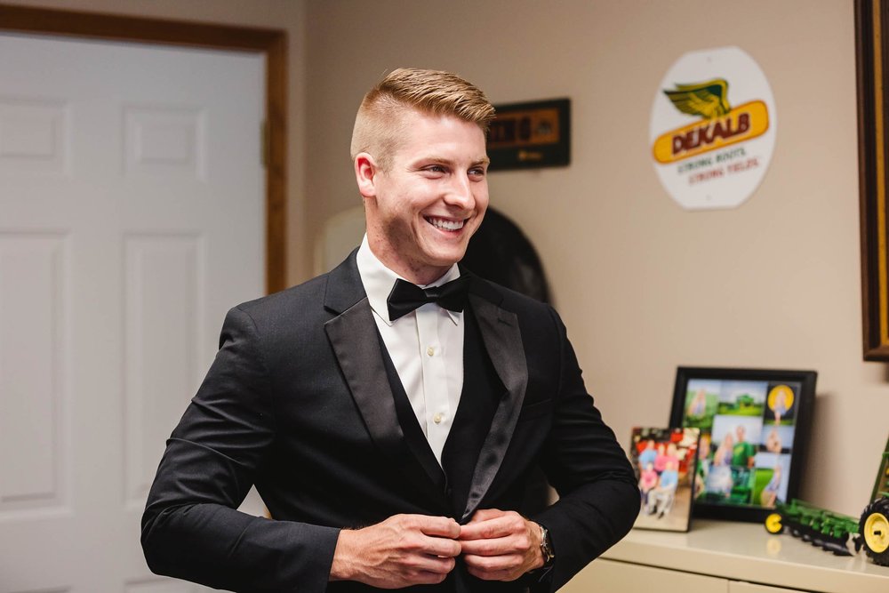 Groom smiles as he gets ready