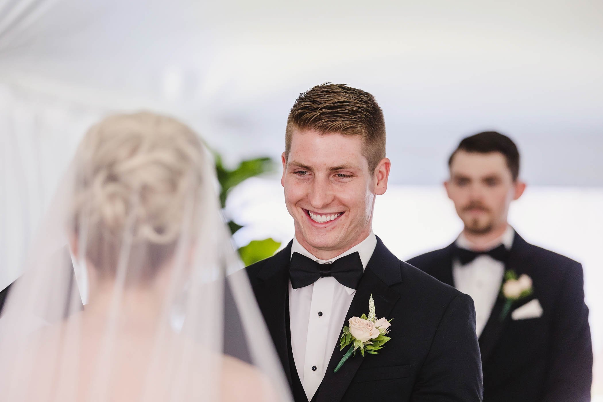 Groom smiles at bride