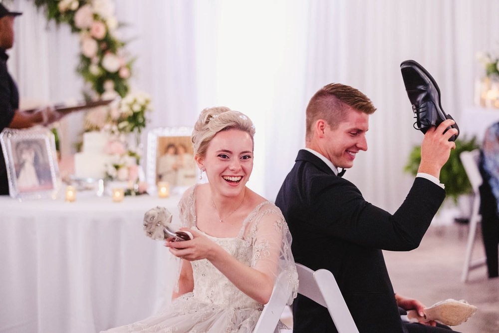Bride and groom laugh during shoe game