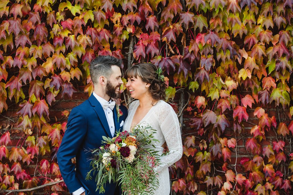 Bride and Groom with Ivy Wall in Fall