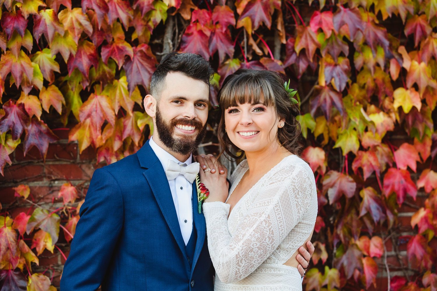 Bride and groom with Fall color ivy wall in Peoria Illinois
