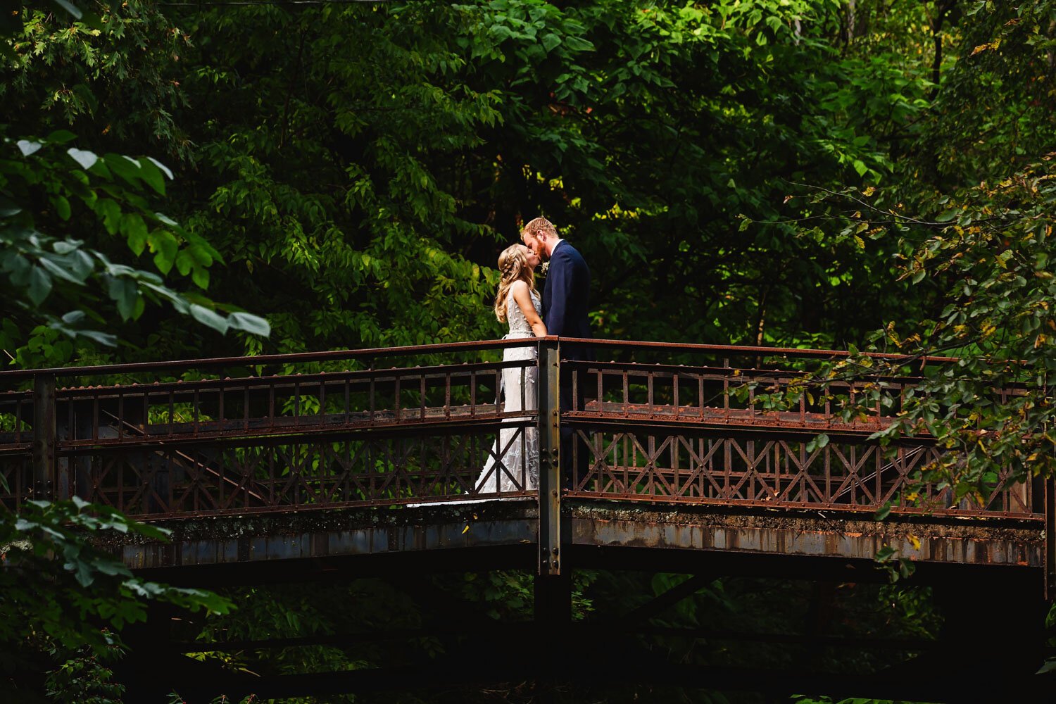 Bride and groom on bridge at Laura Bradley Park