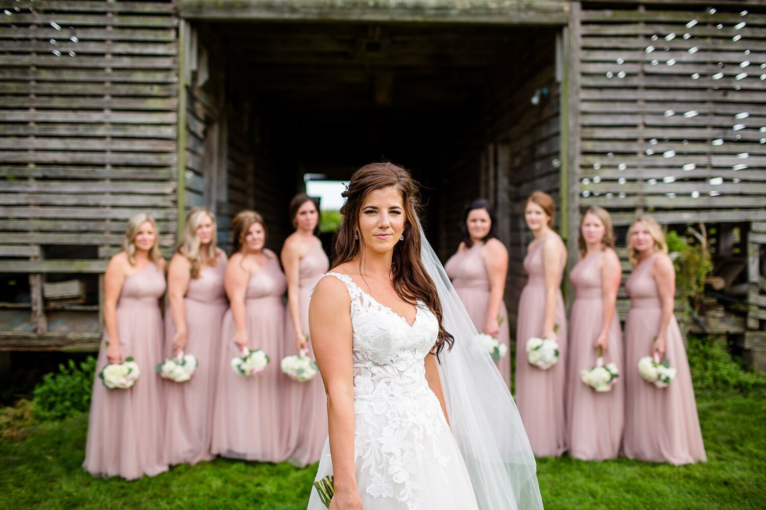 Bride and bridesmaids with barn