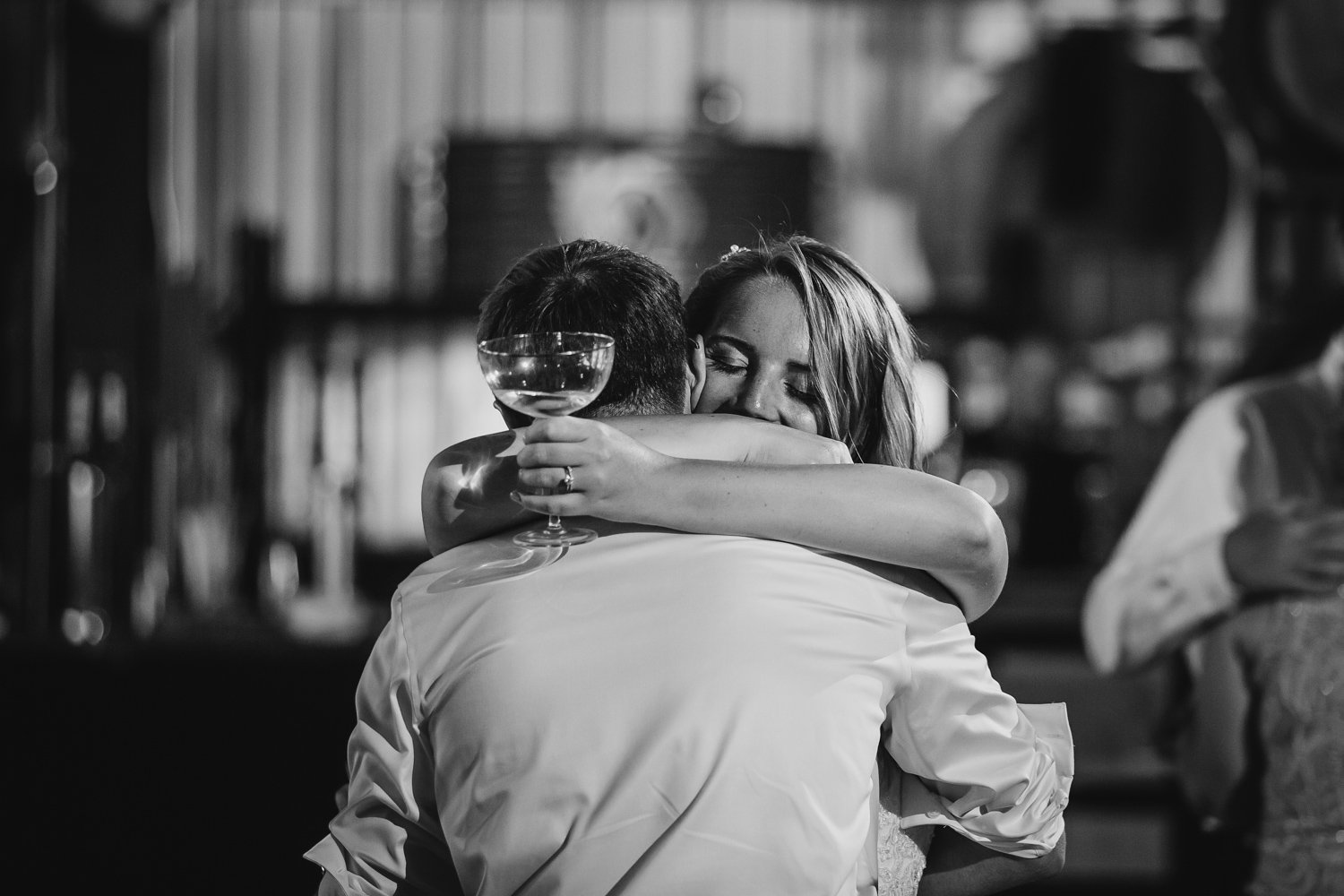 Bride and groom hug at brewery wedding