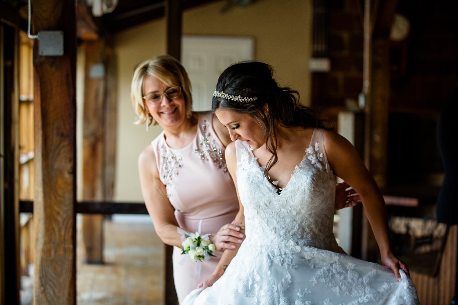Mother helping bride with wedding dress