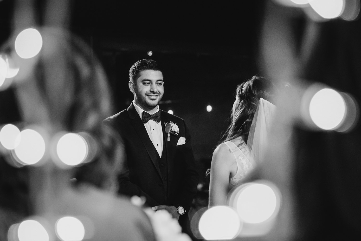 Groom smiles at bride